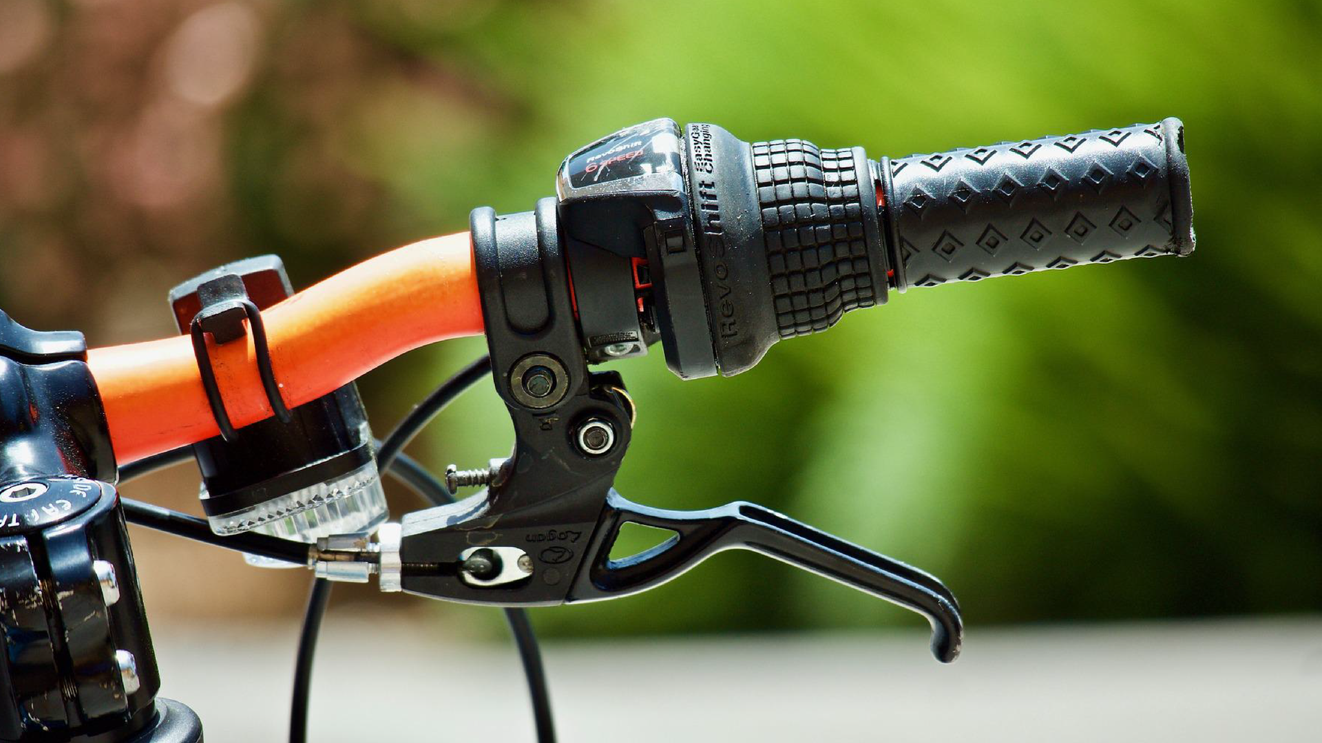 Zdjęcie przedstawia zbliżenie na prawą część kierownicy rowerowej. Widoczna jest manetka hamulca.