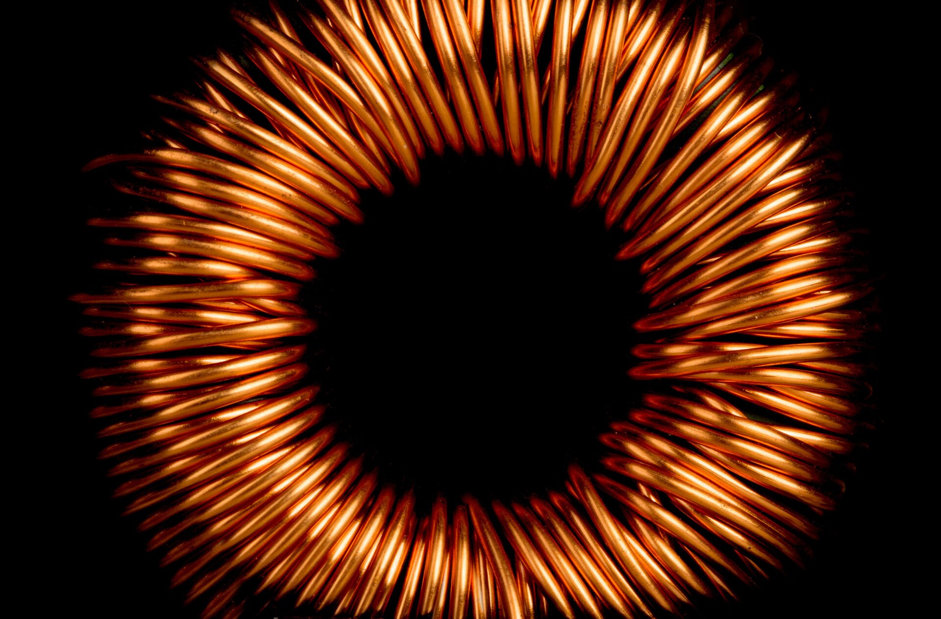 Zdjęcie poglądowe przedstawia zwojnicę wykonaną z miedzianego drutu i przypominającą obwarzanek. Zwojnicę pokazano na czarnym tle. 