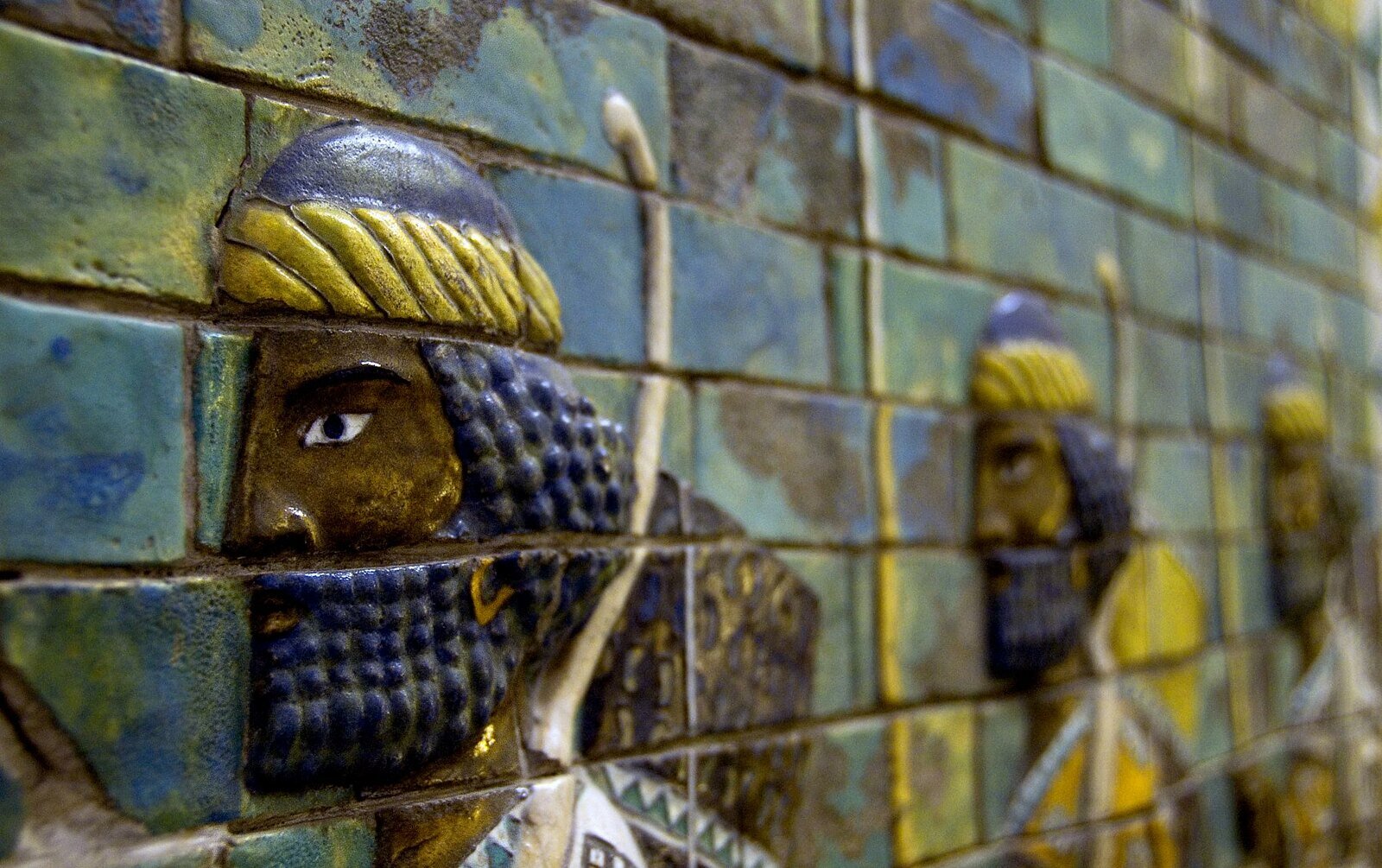 Zdjęcie przedstawia kolorową płaskorzeźbę, prezentującą kilku mężczyzn z niebieskimi brodami i okrągłymi nakryciami głowy.