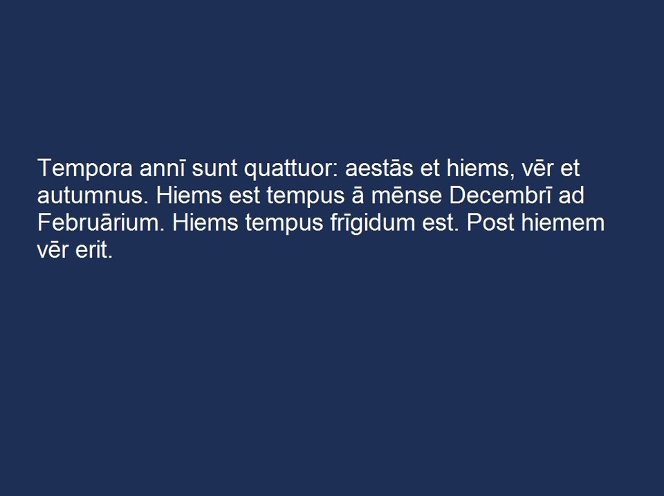 Plansza z białym napisem na ciemnoniebieskim tle:
„ Tempora annī sunt quattuor: aestās et hiems, vēr et autumnus. Hiems est tempus ā mēnse Decembrī ad Februārium. Hiems tempus frīgidum est. Post hiemem vēr erit.”