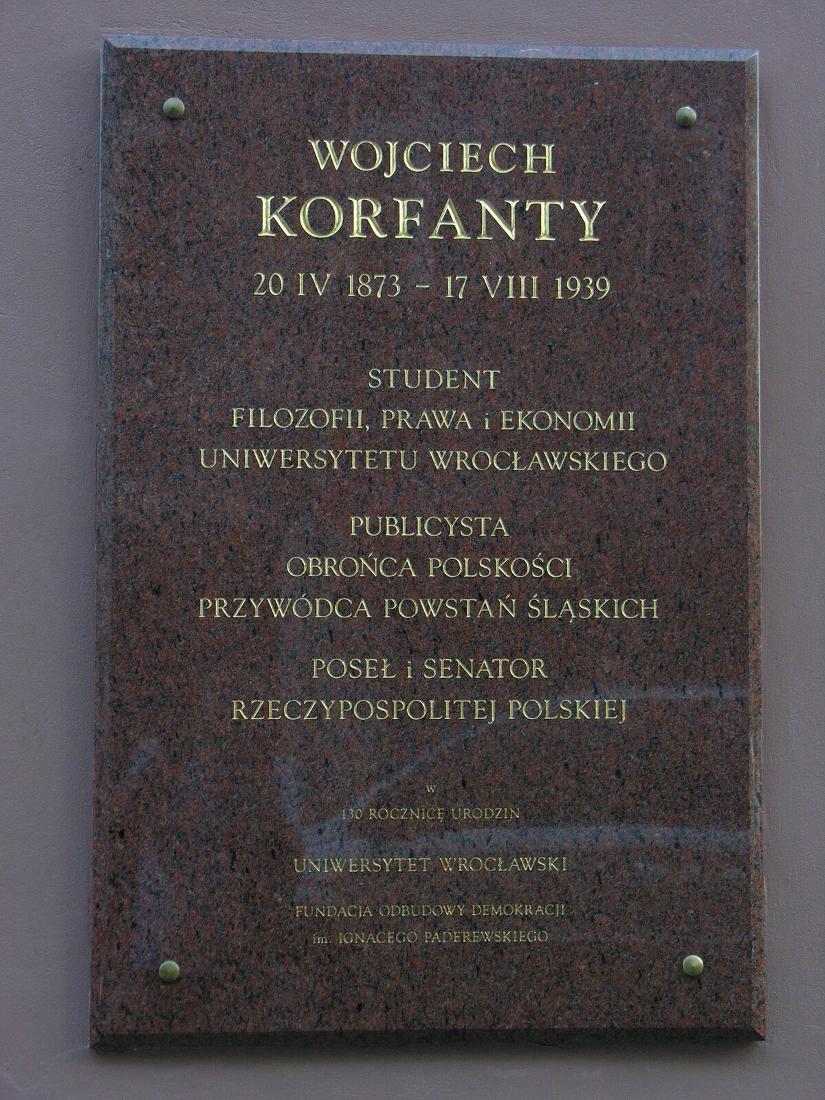 Zdjęcie przedstawia kamienną tablicę pamiątkową ku czci Wojciecha Korfantego wiszącą na ścianie budynku we Wrocławiu. Na niej napis: „Wojciech Korfanty. 20 IV 1873 - 17 VIII 1939. Student filozofii, prawa, ekonomii Uniwersytetu Wrocławskiego. Publicysta. Obrońca polskości. Przywódca powstań śląskich. Poseł i senator Rzeczypospolitej Polskiej. W 130. rocznicę urodzin. Uniwersytet Wrocławski. Fundacja odbudowy demokracji im. Ignacego Paderewskiego. 