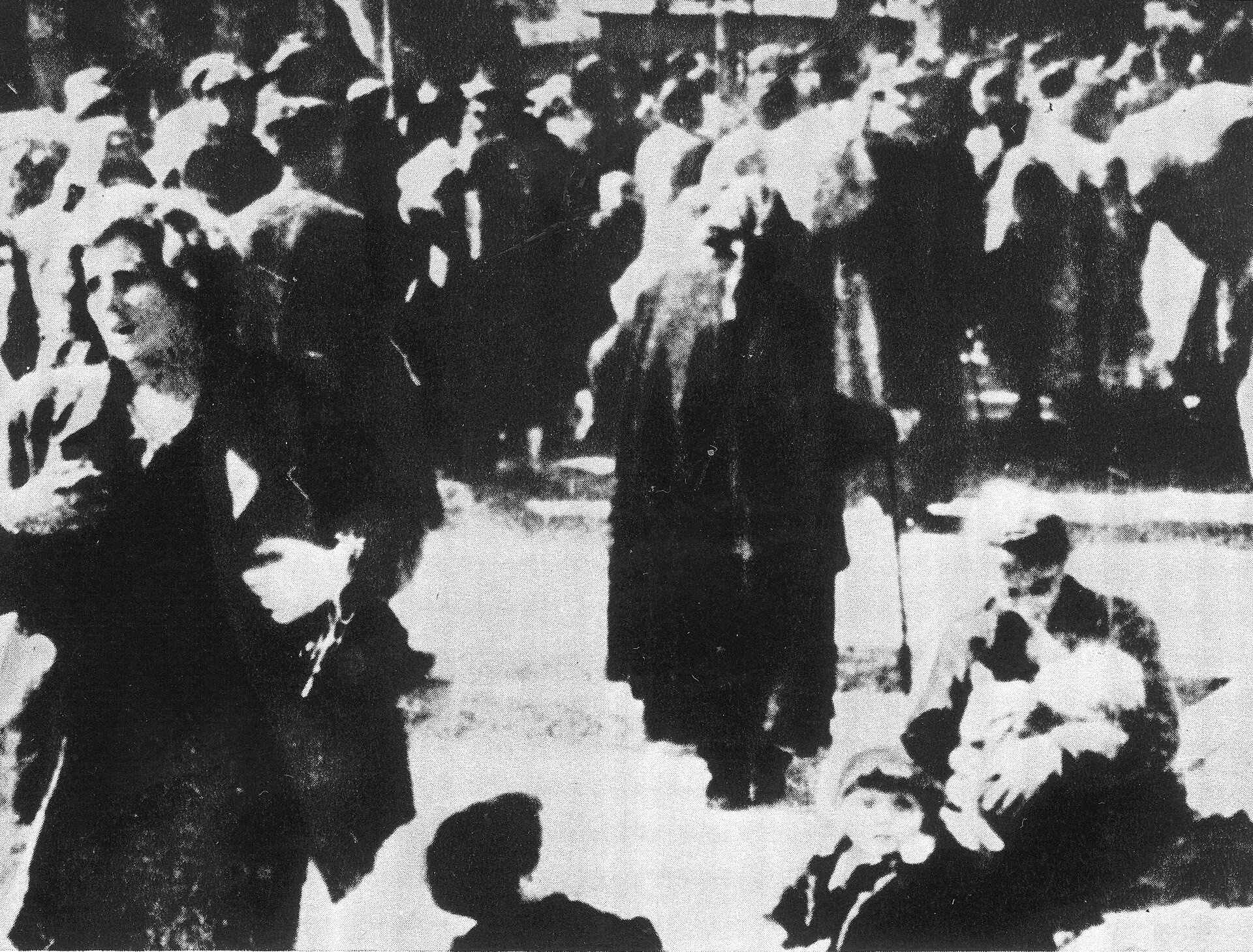 Zdjęcie pokazuje mieszkańców Woli chodzących po placu.