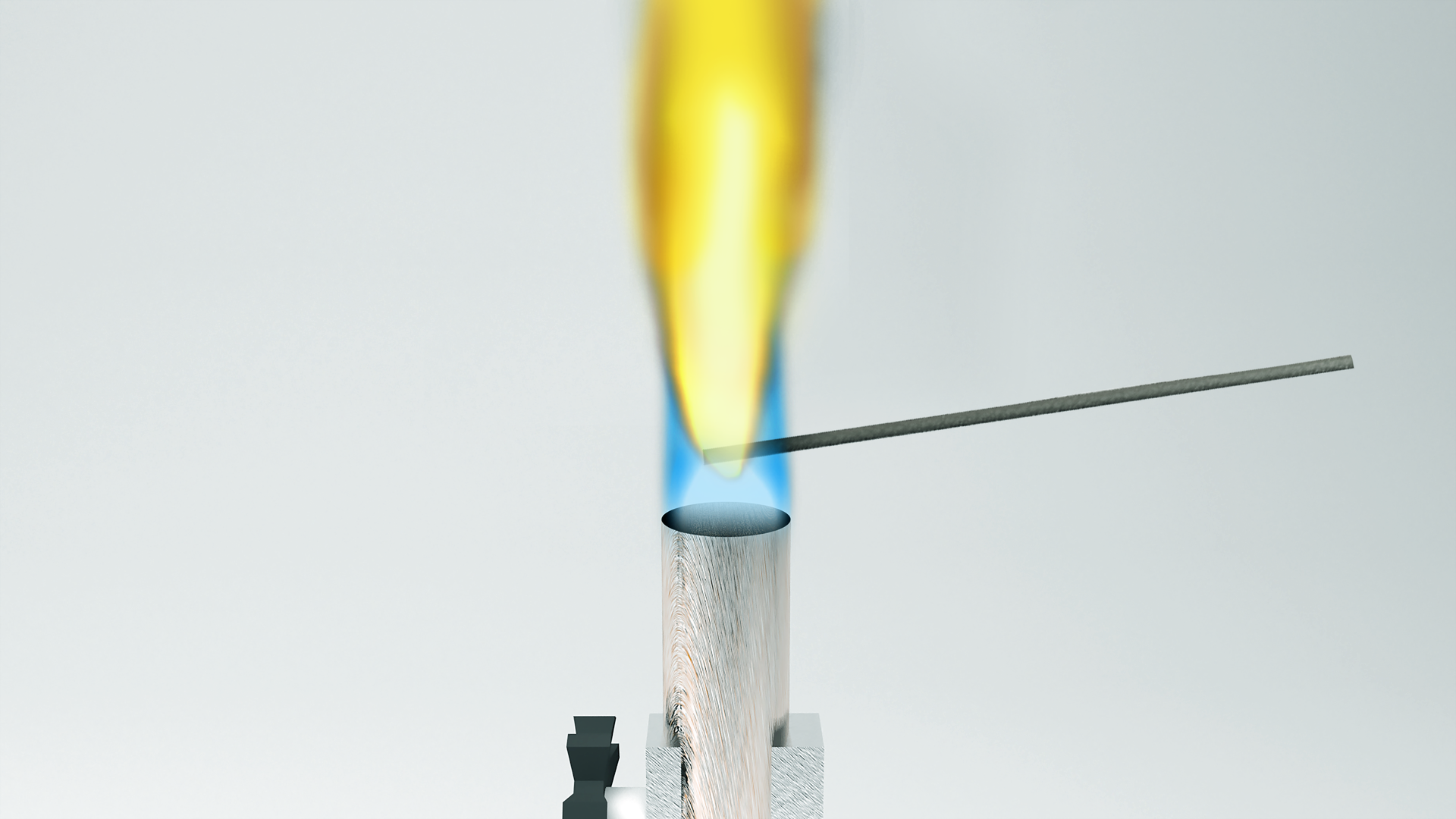 Ilustracja przedstawia schemat jakościowej analizy pierwiastków. Do płomienia palnika włożono bagietkę z próbką. Płomień palnika na dole jest niebieski, a od bagietki w górę jest intensywnie pomarańczowy.