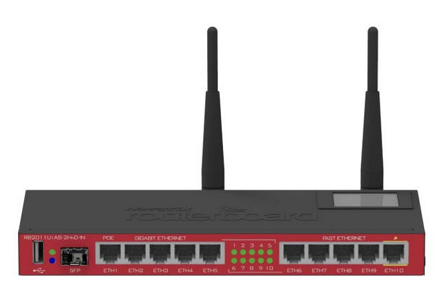 Router MikroTik w charakterystycznej czerwono‑czarnej obudowie z dwoma pionowymi antenami Wi‑Fi. Na przednim panelu znajduje się dziesięć portów Ethernet. Po lewej stronie znajdują się dodatkowe złącza: port USB, slot SFP (dla połączeń światłowodowych) oraz diody sygnalizujące status połączeń. W prawym górnym rogu routera znajduje się mały ekran LCD. Urządzenie umożliwia zarówno przewodowe, jak i bezprzewodowe połączenia sieciowe.