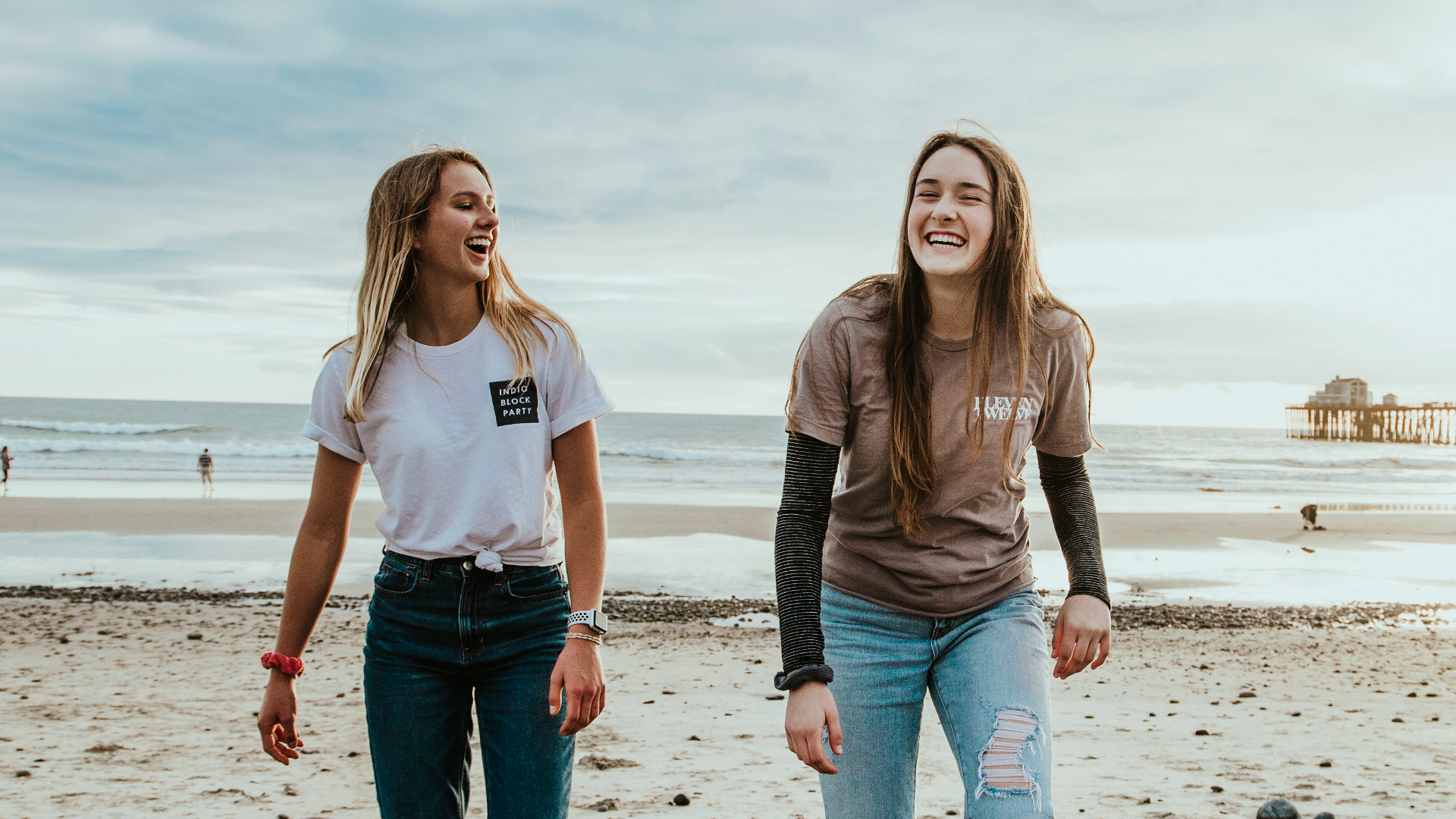 Zdjęcie przedstawia dwie wesołe nastolatki nad brzegiem morza.