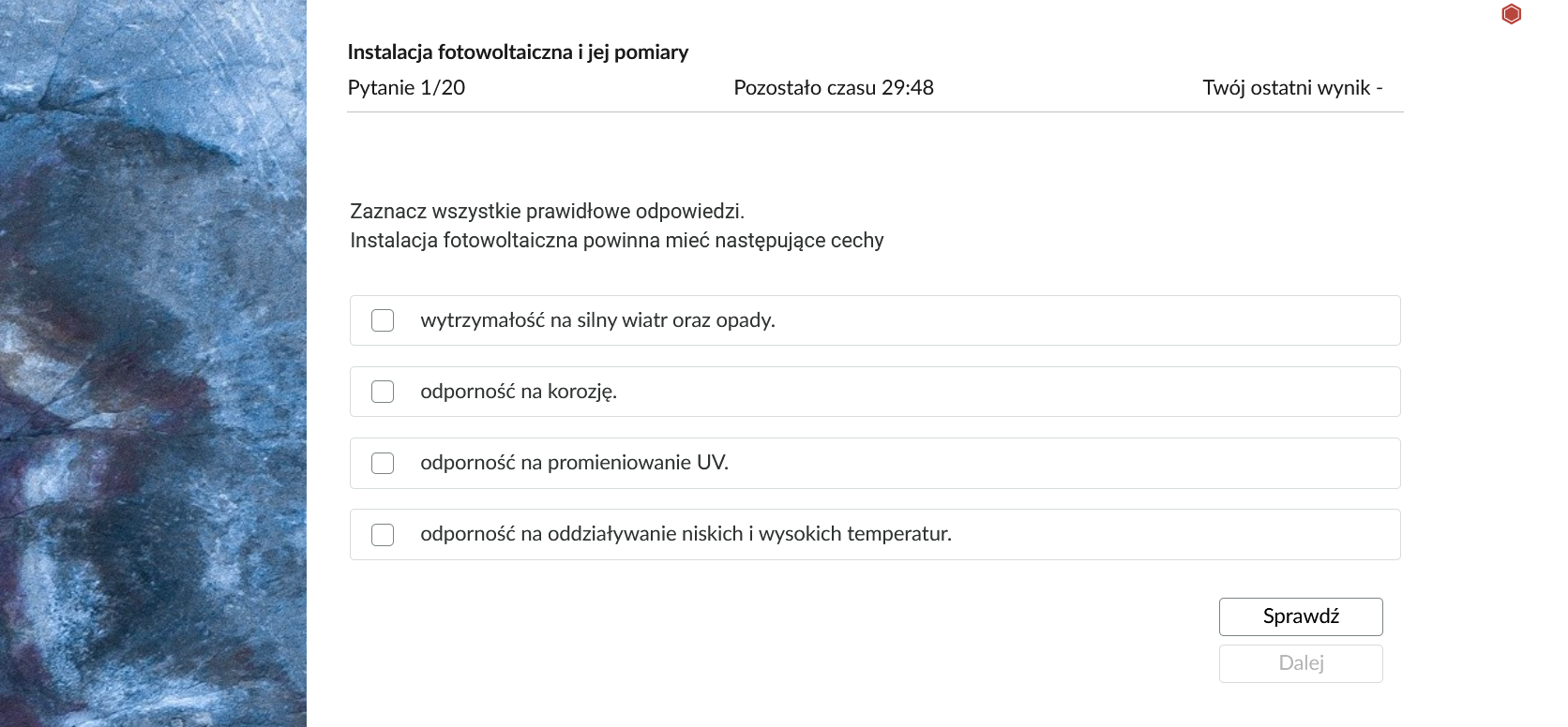 Grafika przedstawia przykładowe zadanie testowe. Ponad poleceniem widać numer pytania, czas, który pozostał na wypełnianie testu, oraz ostatni uzyskany wynik. Pod poleceniem znajdują się możliwe odpowiedzi. W prawym dolnym rogu panelu z zadaniem znajdują się dwa przyciski. Są to "Sprawdź" oraz "Dalej".