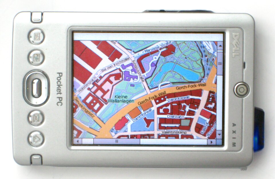 Na zdjęciu znajduje się nieduże urządzenie w metalowej, srebrnej obudowie. Większość przestrzeni urządzenia zajmuje ekran, na którym widoczna jest fragment mapy miasta z napisami w języku niemieckim. Po prawej od ekranu znajduje się przycisk włącznika. Po lewej od ekranu umieszczona jest kolumna przycisków. Widnieje tam też napis "Pocket PC".