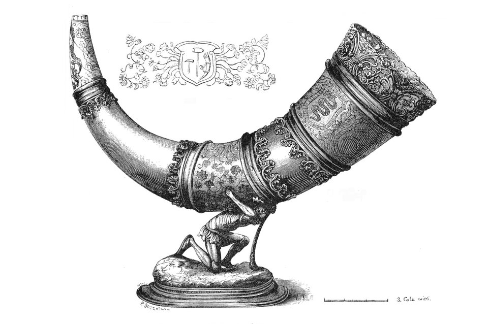 Ilustracja przedstawia złoty róg – bogato zdobiony instrument o kształcie zagiętego rogu, spoczywający na podstawie w formie figury człowieka, który go podtrzymuje. Róg jest podzielony na ozdobne segmenty z ornamentami roślinnymi i geometrycznymi, a jego powierzchnia zdobiona jest misternymi reliefami i grawerunkami.