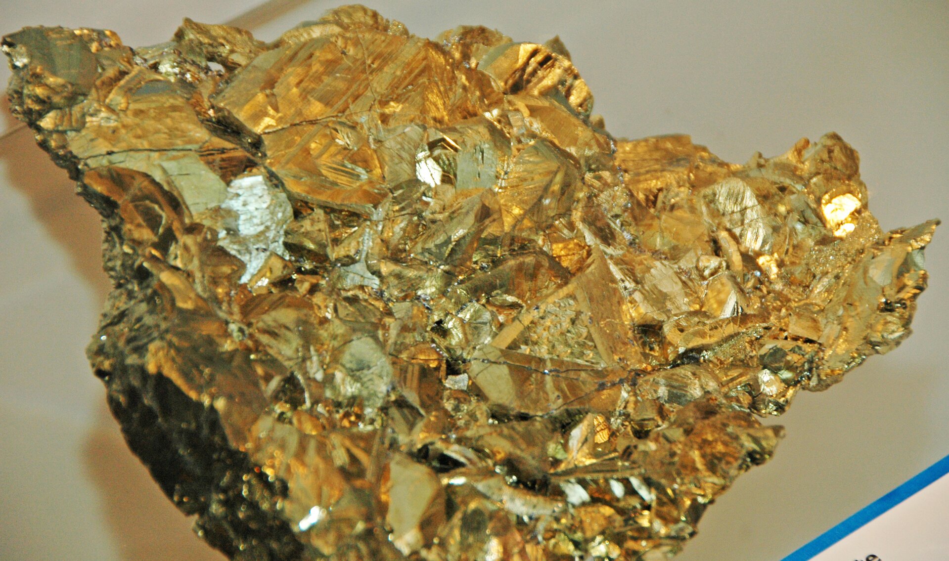 Zdjęcie przedstawia minerał przypominający zlepek złotych kawałków.