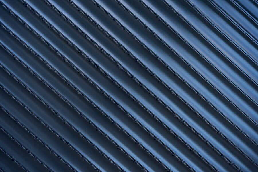 Zdjęcie przedstawia profilowaną, szarą blachę. Szczegółowy opis obiektu znajduje się w zaprezentowanej definicji.