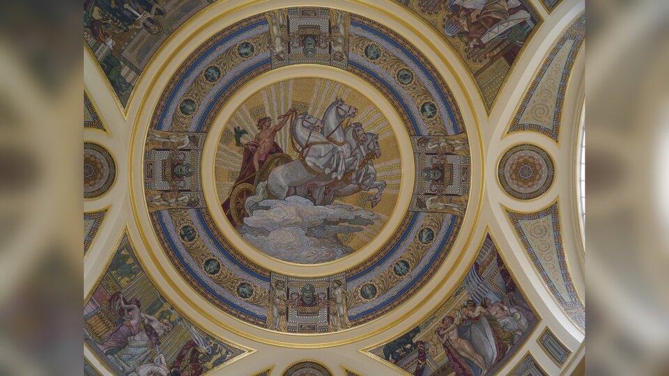 Obraz przedstawia fresk znajdujący się na kopule budynku. To jadący rydwanem, młody, nago mężczyzna. Rydwan zaprzężony jest w cztery białe konie.