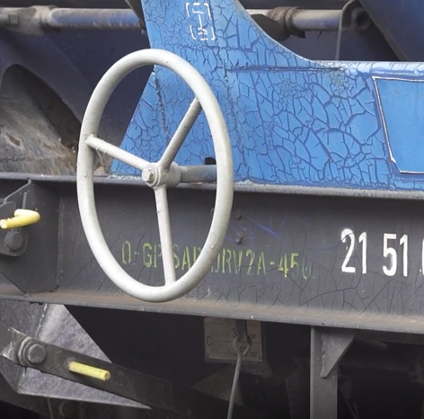 Zdjęcie przedstawia hamulec postojowy. Widoczne jest okrągłe pokrętło hamulca umieszczone na boku wagonu.