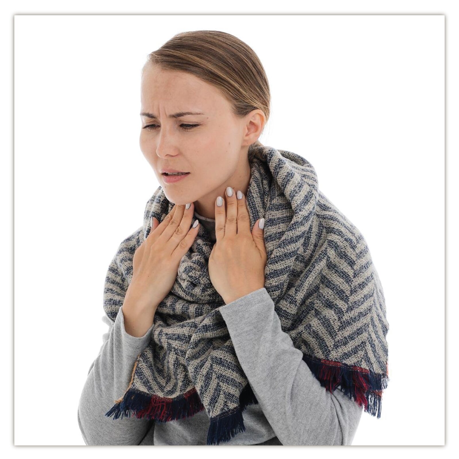 Na zdjęciu widoczna jest kobieta w szaliku. Kobieta ma na twarzy grymas bólu i trzyma się za gardło.