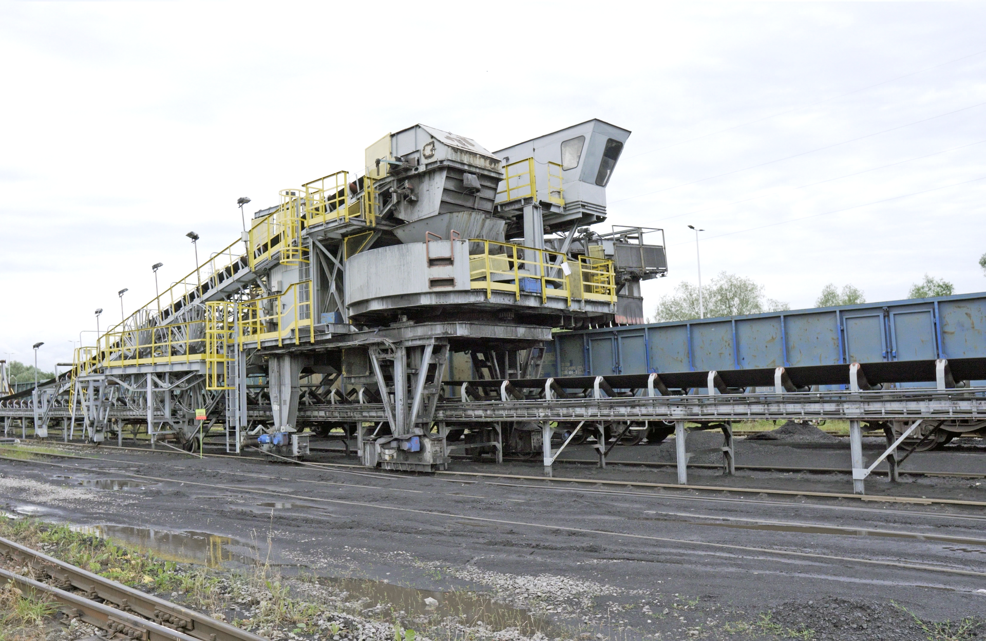 Na zdjęciu widać nasypywarkę widoczną od tyłu. Na dole maszyny znajduje się tor po którym urządzenie się porusza. Nasypywarka zbudowana jest z dużej galerii której centralnym elementem są dwa duże koła. Koła przypominają koła parowca. Na górze nasypywarki zamontowany jest przenośnik taśmowy.