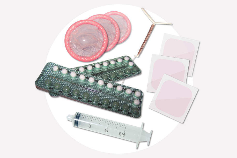 Fotografia przedstawia środki antykoncepcyjne. U góry z lewej 3 różowe, zwinięte prezerwatywy. Obok biała kształtka z nawiniętym miedzianym drucikiem, czyli spirala. W prawo 3 bladoróżowe plastry hormonalne. W centrum dwa blistry z tabletkami hormonalnymi. U dołu plastikowa strzykawka, symbolizująca zastrzyk hormonalny. The photograph shows contraceptives. At the top left 3 pink, rolled up condoms. Next to it is a white shape with a copper wire wound around it, ie a spiral. Right 3 pale pink hormonal patches. In the center two blisters with hormonal tablets. At the bottom, a plastic syringe, symbolizing a hormonal injection.