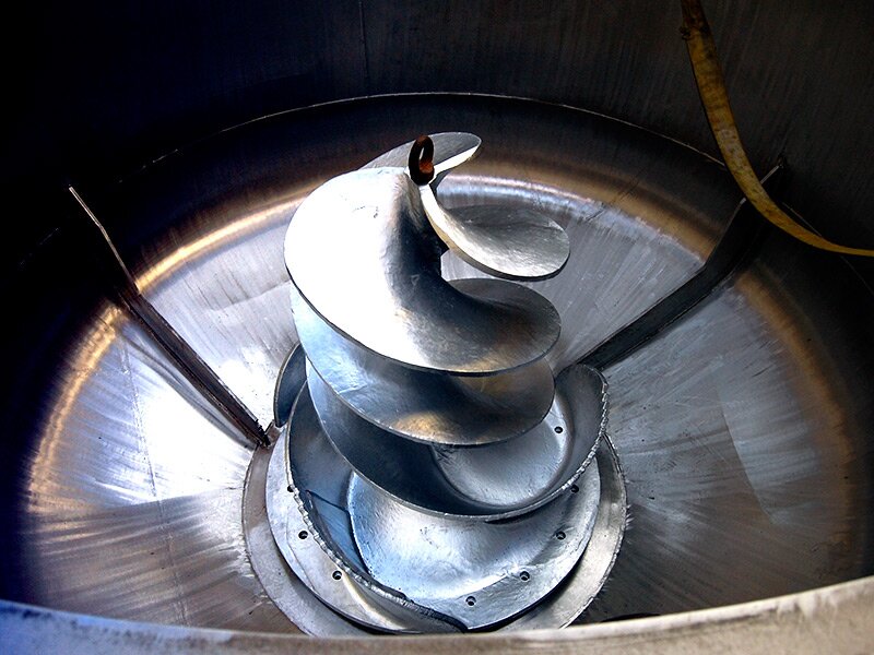 Zdjęcie przedstawia hydropulper. Jest to urządzenie mające postać dużego zbiornika, w centralnej części znajduje się spiralny metalowy wirnik oraz łopatki służące do mieszania masy.