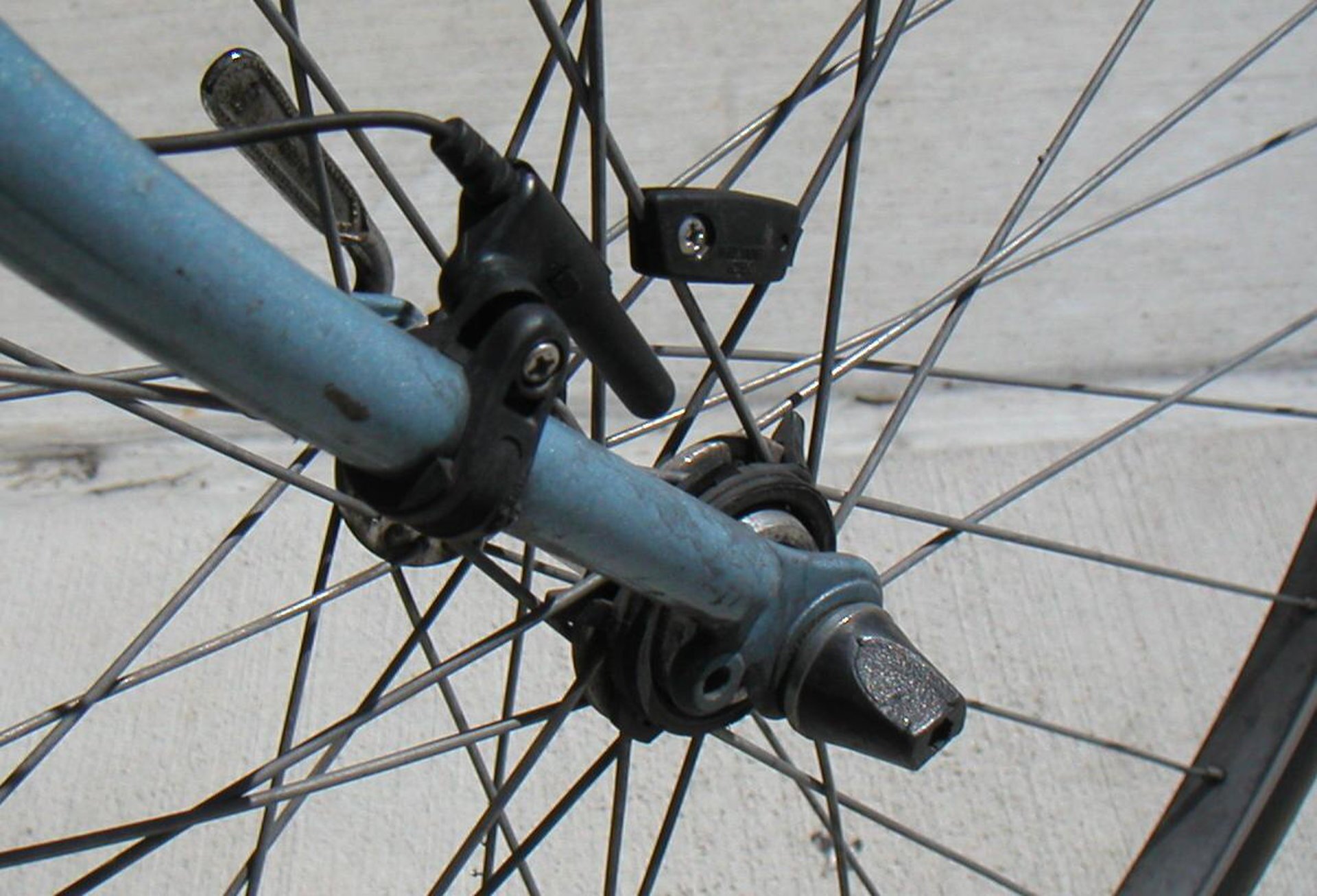 Rys. 1. Ilustracja przedstawia zdjęcie dwóch czujników licznika rowerowego zamontowanych jeden na widelcu przedniego koła a drugi na szprysze koła. Czujniki zamontowane są na tej samej wysokości. W chwili, gdy mijają się podczas obrotu koła rowerowego generowany jest impuls. Na podstawie informacji o czasach jakie upłynęły pomiędzy kolejnymi impulsami i promieniu koła rowerowego, oblizana jest prędkość liniowa z jaką obraca się koło. 