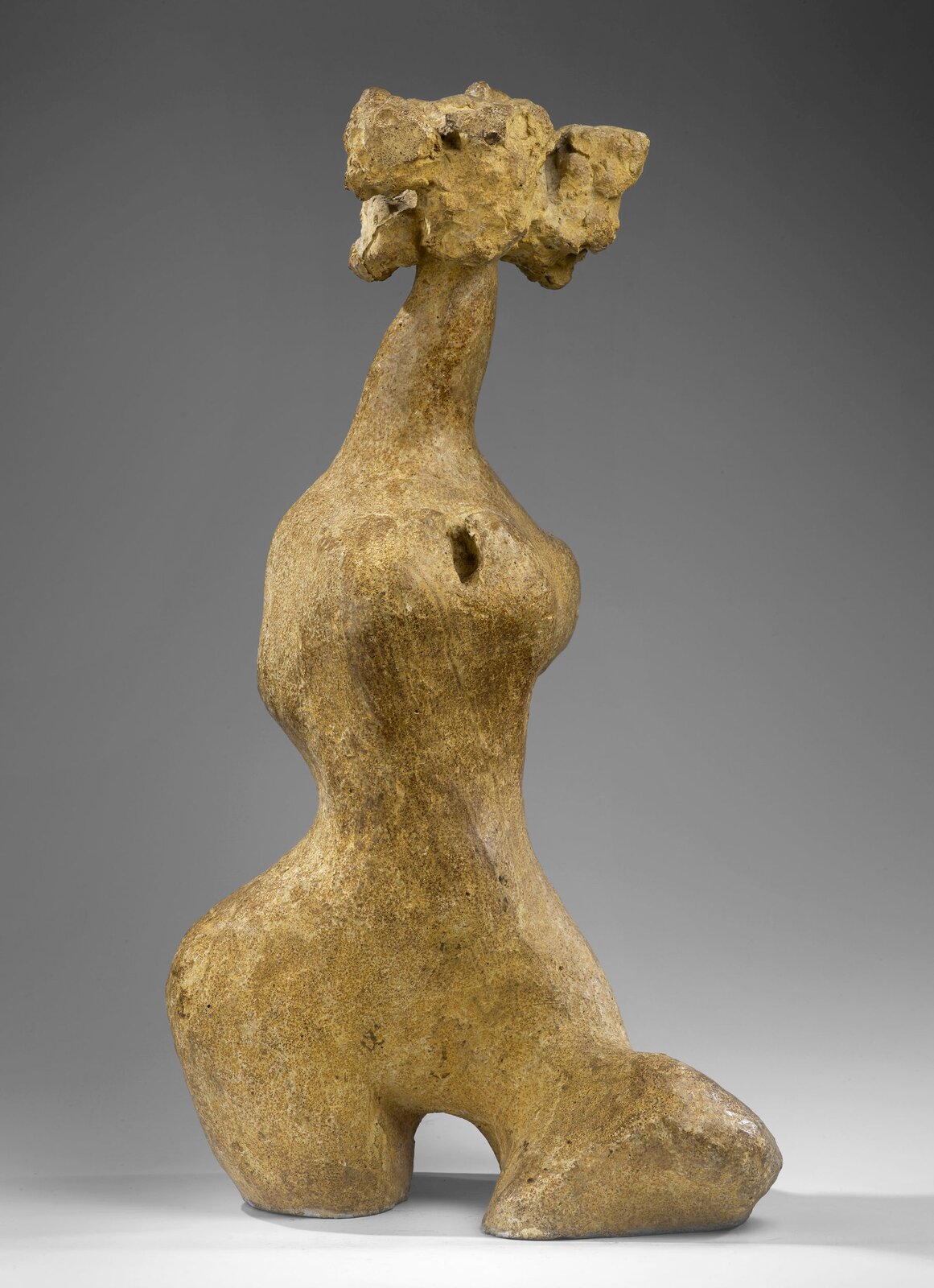 Zdjęcie przedstawia rzeźbę Aliny Szapocznikowej Bellissima., Żółta rzeźba w zarysie przypomina kształt kobiecy, Rzeźba nie ma rąk, posiada krótkie fragmenty ud zamiast nóg.