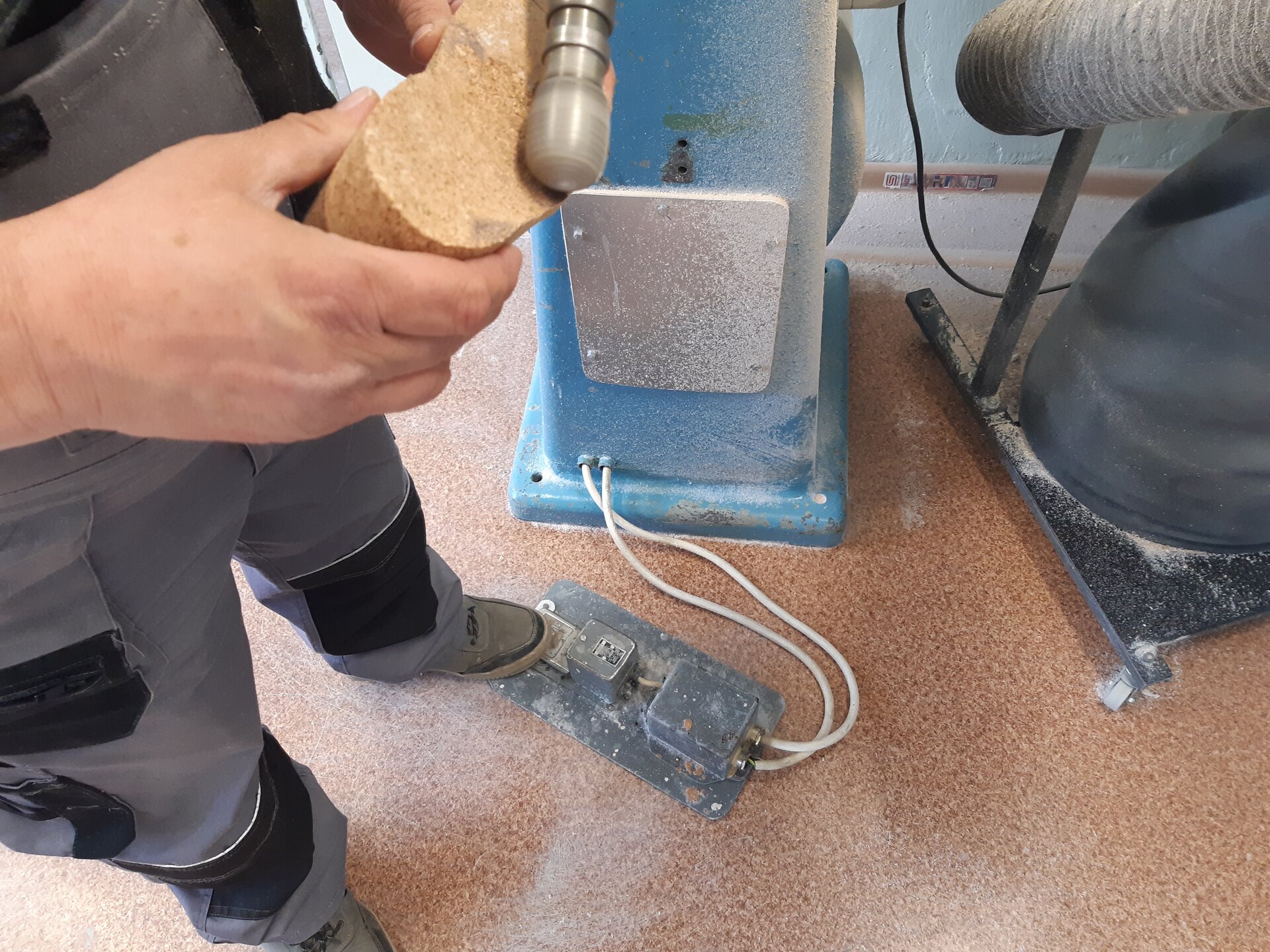 Zdjęcie przedstawia osobę szlifującą wkładkę z płyty suberytowej.