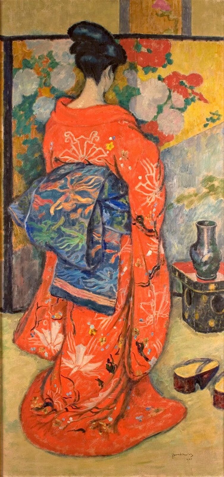 lustracja przedstawia obraz Józefa Pankiewicza pt. „Japonka”. Na obrazie widać ustawiona tyłem kobietę. Ubrana jest w pomarańczowo‑niebieskie kimono. Czarne włosy ma upięte w kok. Kobieta stoi na tle parawanu w kolorowe kwiaty.