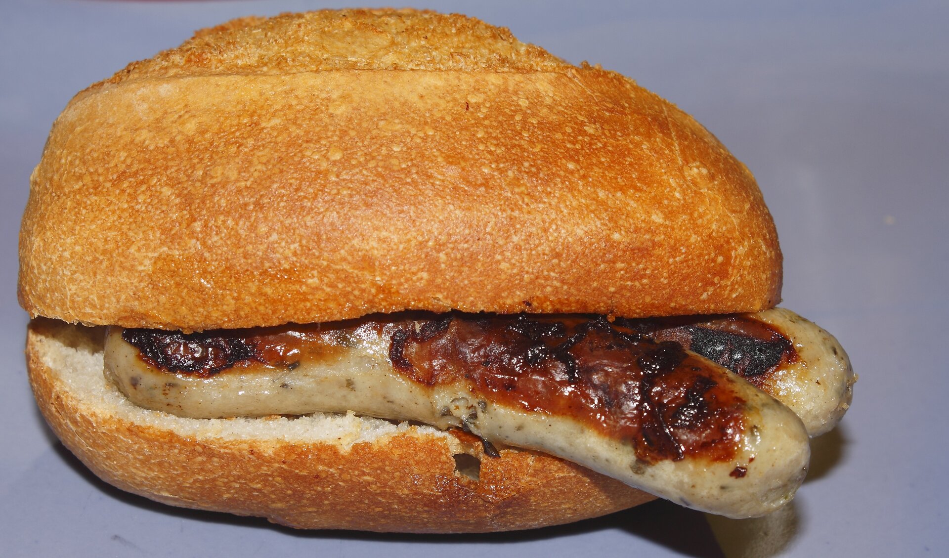 Na ilustracji ukazano bułkę z dwoma smażonymi kiełbasami.