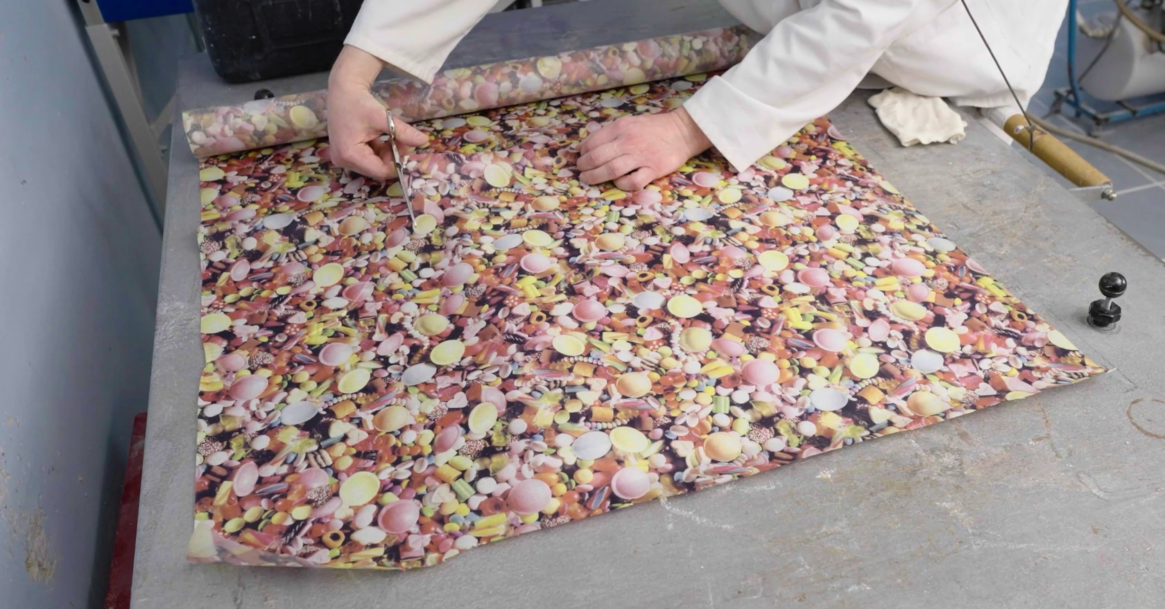 Zdjęcie przedstawia częściowo rozwinięty z rulonu papier termiczny na blacie.