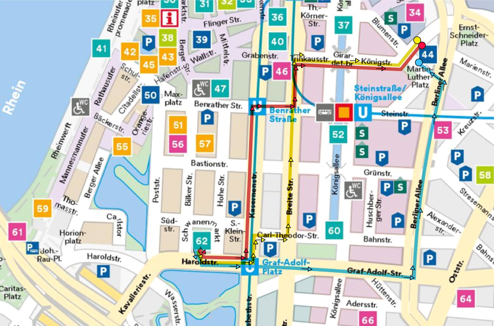 Mapa przedstawia fragment Düsseldorfu. Na planie zaznaczone są nazwy ulic, placów oraz trasy: czerwona, żółta i niebieska prowadzące ze Schwanenmarkt do Martin-Luther-Platz. Trasa czerwona prowadzi ulicami: Haroldstraße, Kasernenstraße, Benratherstraße. Trinkaustraße, Königstraße. Trasa żółta prowadzi ulicami: Haroldstraße, Kasernenstraße, Carl-Theodor-Straße, Breite Straße, Trinkaustraße, Königstraße. Trasa niebieska prowadzi ulicami: Haroldstraße, Graf-Adolf- Straße, Berliner Allee.