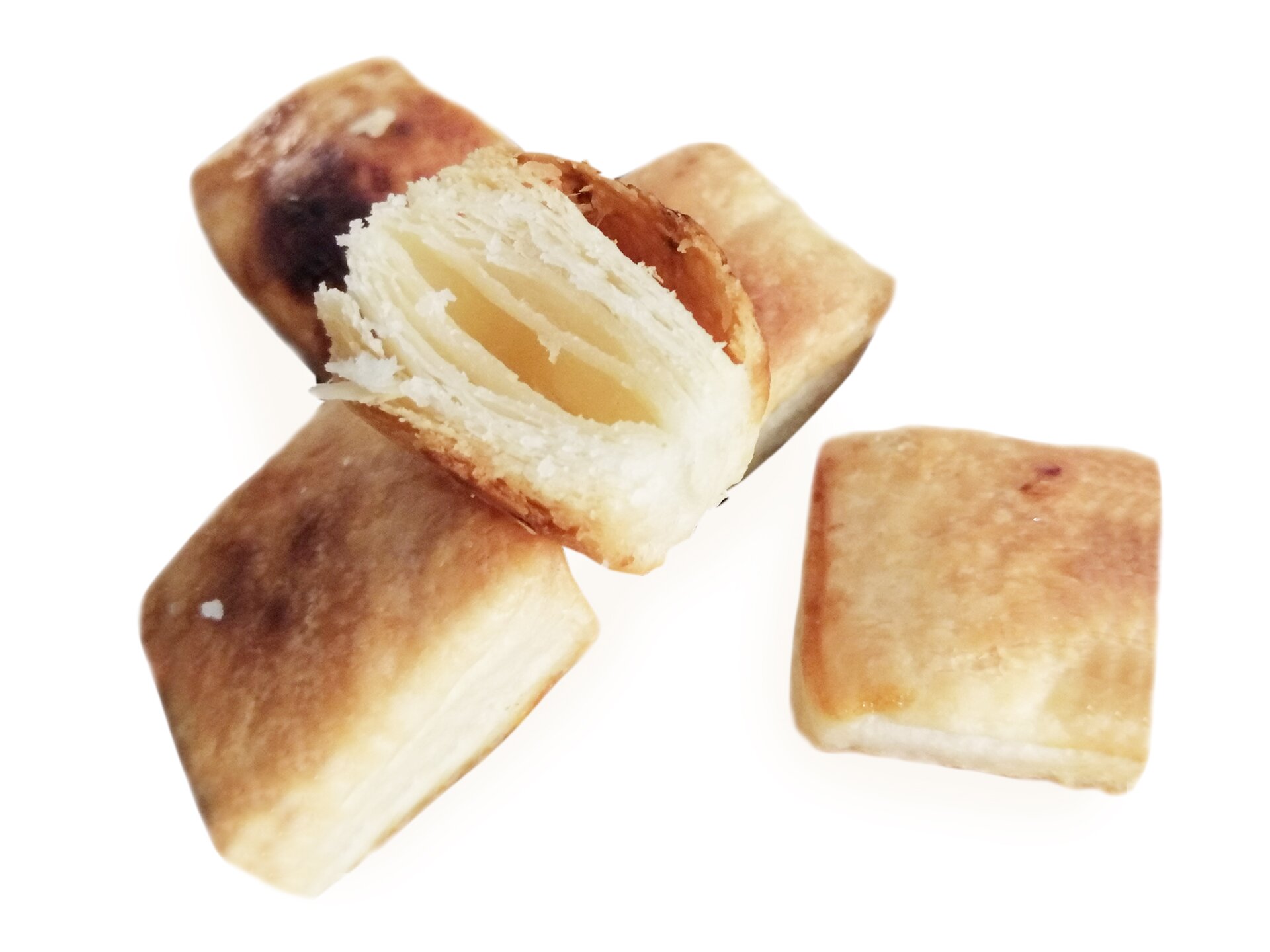 Małe, kwadratowe ciastka, jedno z nich jest przekrojone, widoczny jest środek.