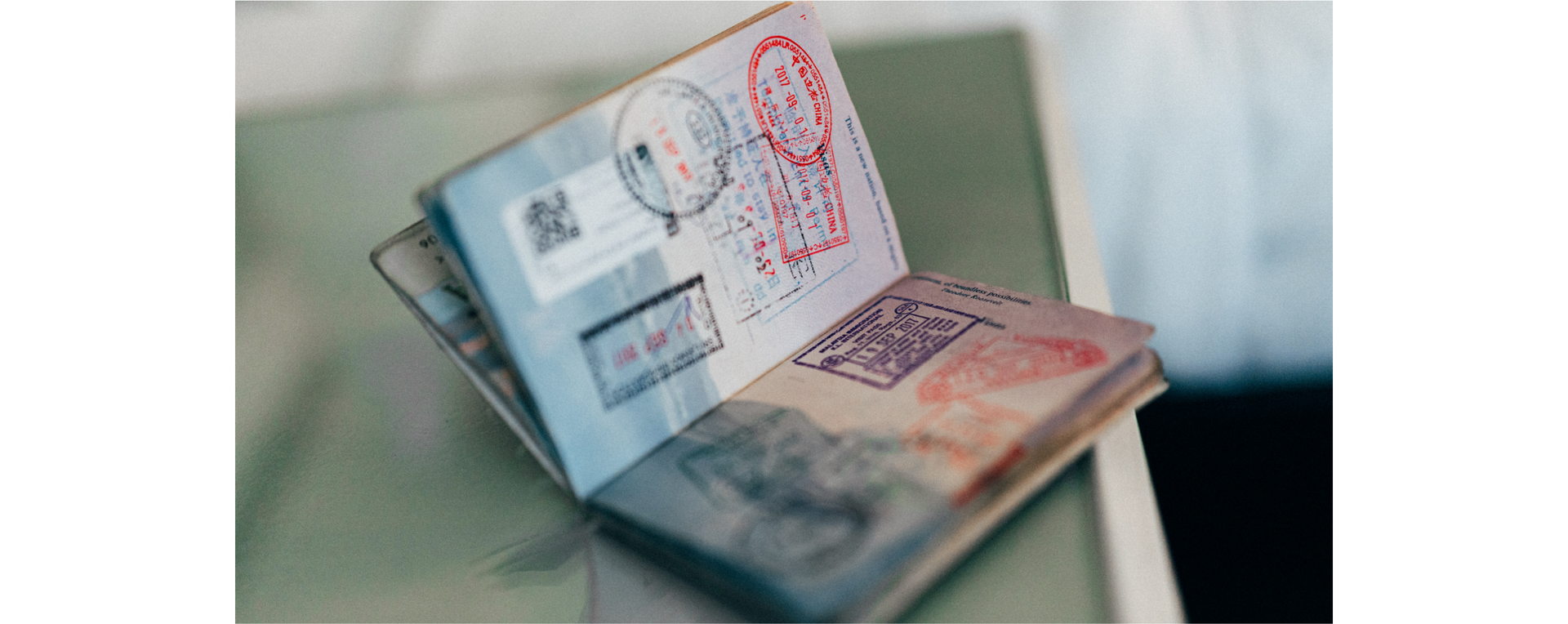 Zdjęcie przedstawia otwarty paszport na stronie z pieczątkami z różnych krajów.