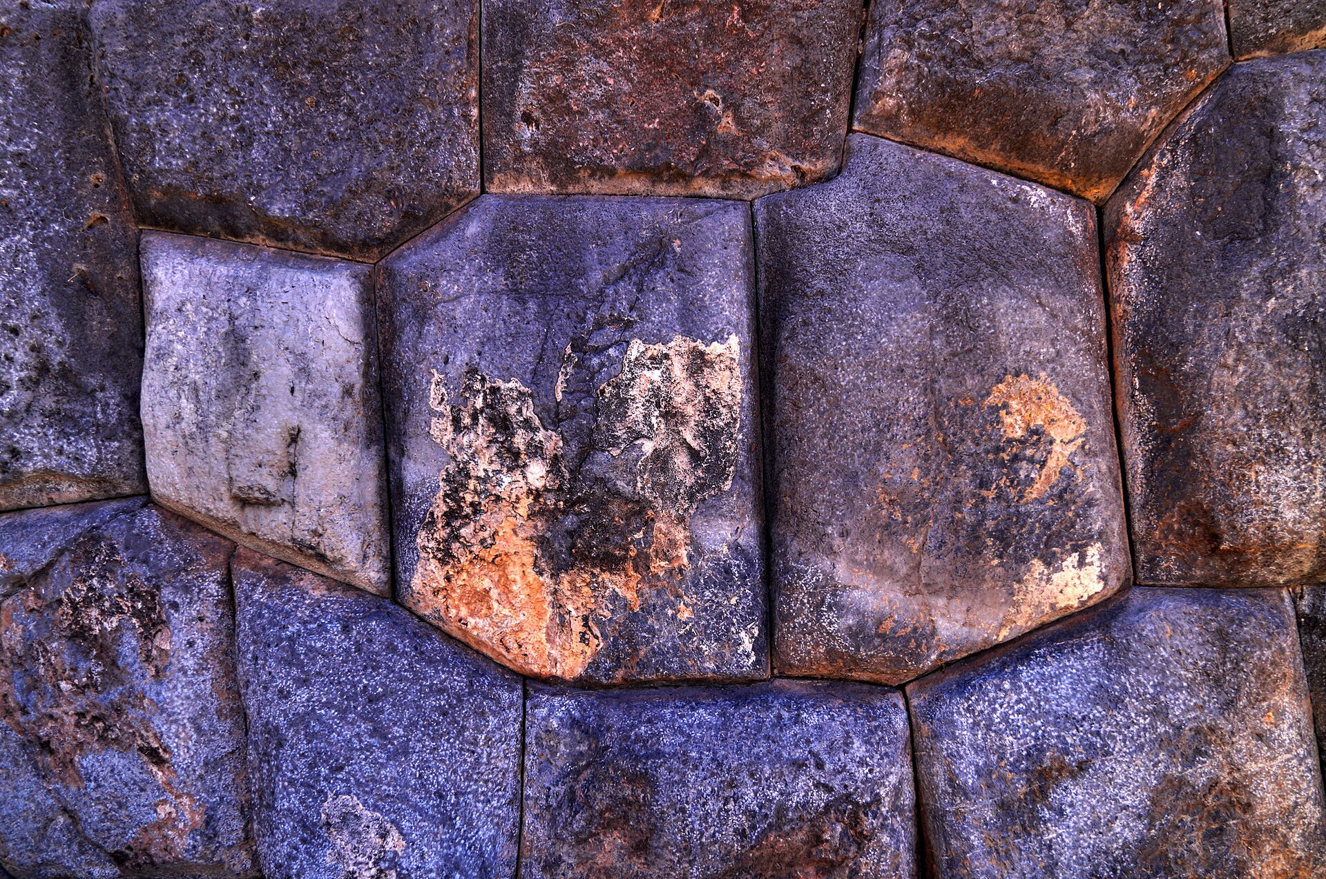 Kliknij, aby powiększyć. Na zdjęciu dwanaście dopasowanych do siebie kamieni. Przylegają mocno do siebie. Część wygląda jakby były złote.