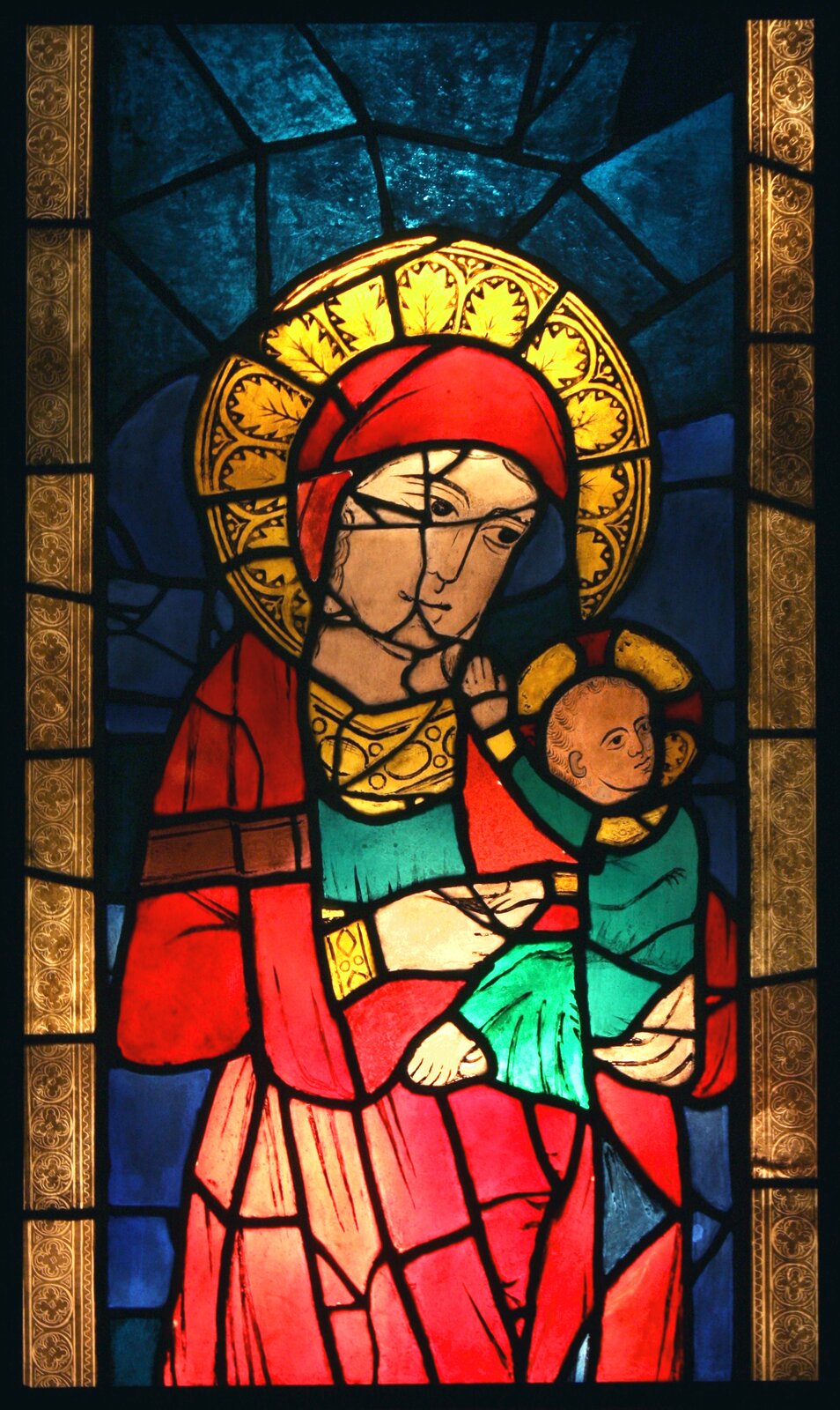 Ilustracja przedstawia witraż z Matką Boską z Dzieciątkiem z kościoła Dominikanów z XIII w. Ukazuje  Madonnę  z małym Jezusem na lewym ramieniu.  Ubrana jest w zieloną suknię i czerwony płaszcz. Jezus w zielonkawej szacie odwraca w prawą stronę. Tło witraża jest niebieskie, po bokach znajdują się złote, pionowe pasy.  