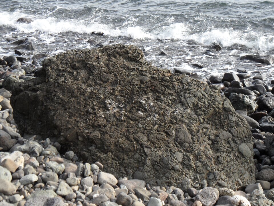 Zdjęcie przedstawia brekcję wulkaniczną. Jest ona zlepkiem materiału wulkanicznego o nieregularnym kształcie i nieregularnej powierzchni. Posiada ciemną barwę.