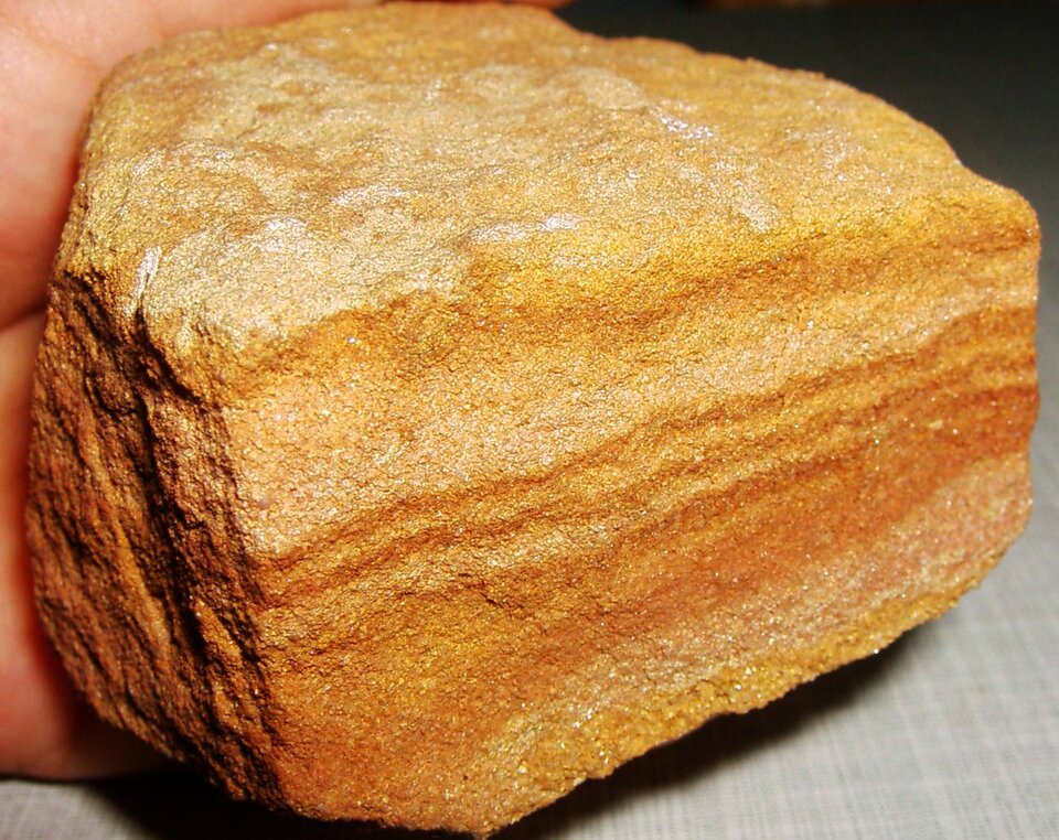 Zdjęcie przedstawia piaskowiec. Ma chropowatą powierzchnię o żółtym zabarwieniu.