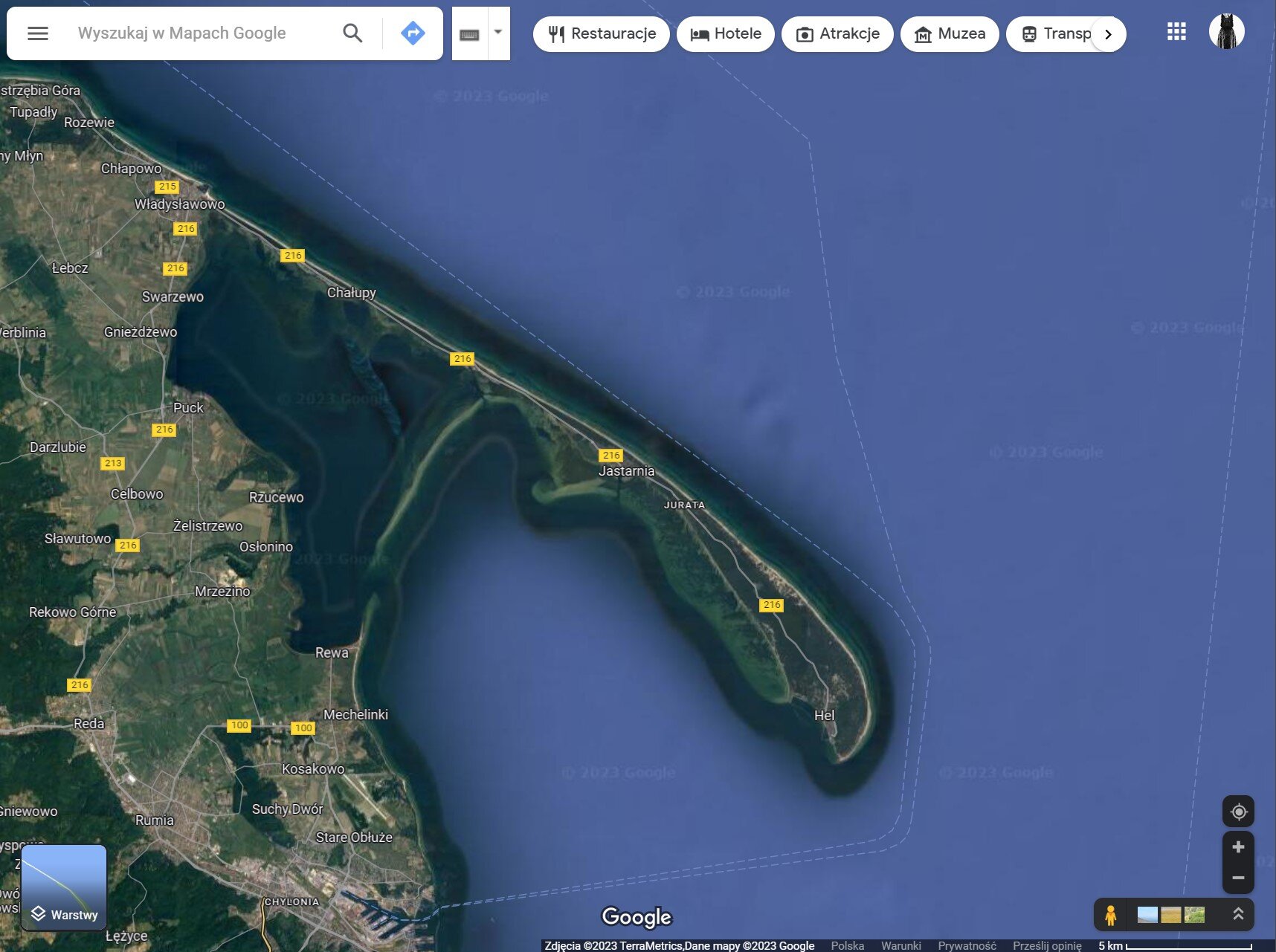 Ilustracja przedstawia fragment mapy Polski, którego treścią jest obraz ze zdjęcia satelitarnego. Na mapie widoczny jest półwysep Hel. Na górze, w dolnych rogach ilustracji elementy portalu mapowego.