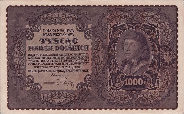 Fotografia przedstawia banknot 1000 marek polskich Polskiej Krajowej Kasy Pożyczkowej z 1919 roku. Z prawej strony, w otoczeniu motywów roślinnych znajduje się portret Kościuszki. Młody mężczyzna o włosach do ramion, patrzy wprost, na szyi ma kokardę. Z lewej strony znajduje się napis: 
Polska Krajowa Kasa Pożyczkowa, 
tysiąc marek polskich
Państwo polskie bierze na siebie odpowiedzialność za wymianę niniejszego biletu na przyszłą walutę  polską według stosunku, który dla marek polskich uchwali sejm ustawodawczy. 
Warszawa, dnia 23 sierpnia 1919 roku
Dyrekcja Polskiej Krajowej Kasy Pożyczkowej
Poniżej nieczytelne dwa podpisy.