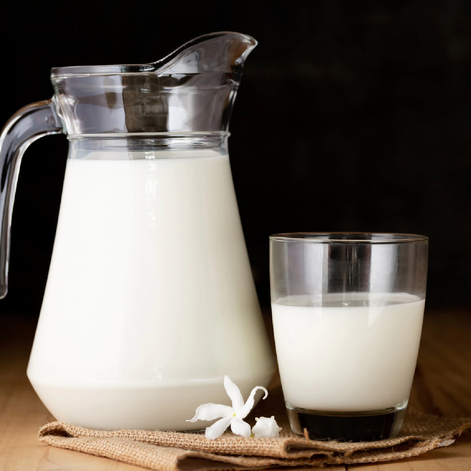 Zdjęcie przedstawia dzbanek i szklankę wypełnione mlekiem.