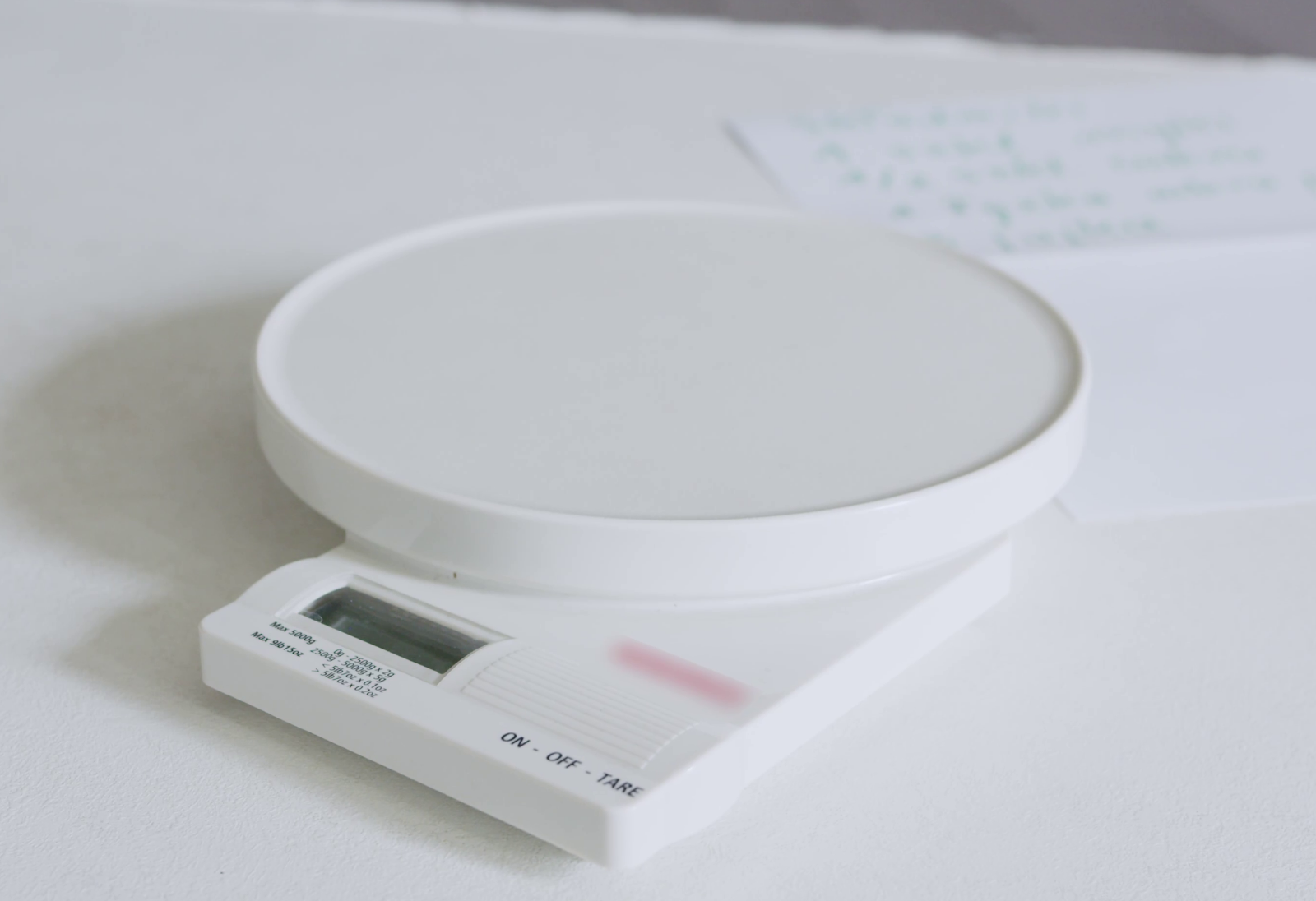 Zdjęcie przedstawia udźwiękowioną wagę kuchenną. Waga wyposażona jest z wyświetlacz, przyciski sterujące oraz okrągłe miejsce do ważenia produktów.