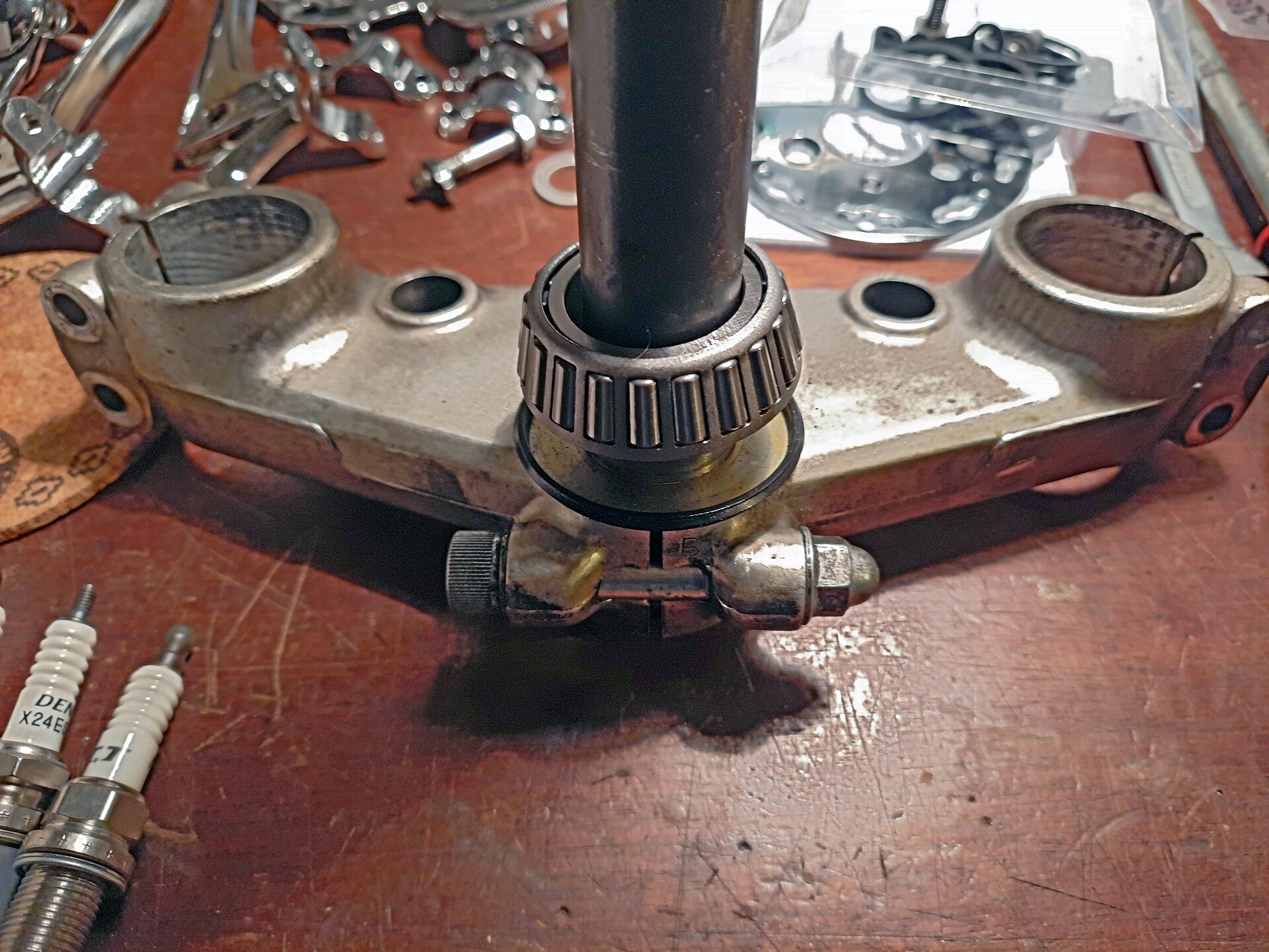 Na ekranie przedstawiona nowa bieżnia łożyska sterowego i nowy uszczelniacz łożysk przygotowane do zamontowania na sztycy półek zawieszenia.