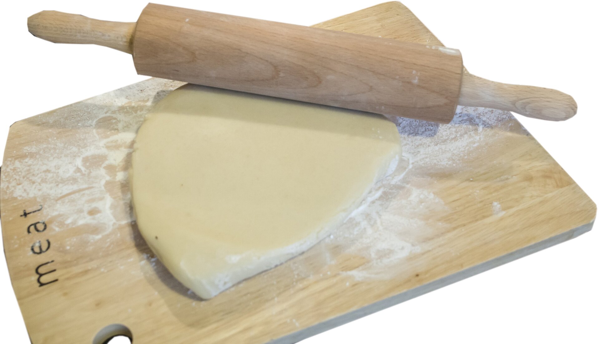 Zdjęcie przedstawia marcepan naturalny. Widoczna jest drewniana deska, na której znajduje się rozwałkowany marcepan, na którym widoczny  jest leżący drewniany wałek.