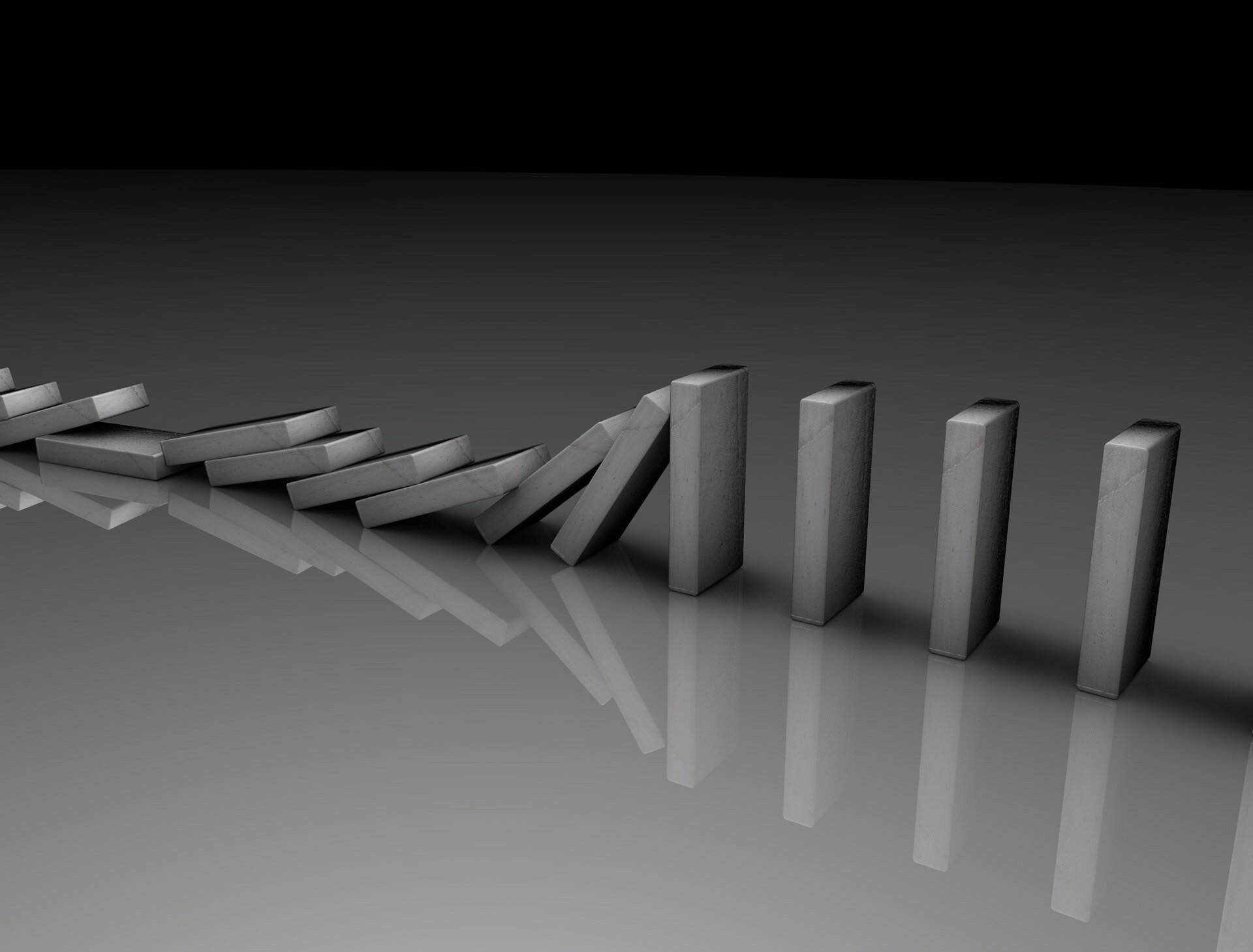 Ilustracja animowana przedstawia upadające kostki domina, które są ustawione obok siebie. Pierwsza kostka jest pchnięta ręką.