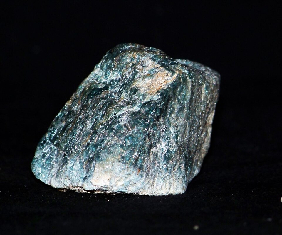 Zdjęcie przedstawiające minerał mający barwę szarą, gdzieniegdzie zielonkawo‑niebieską. Ma metaliczny połysk i zwartą budowę. 