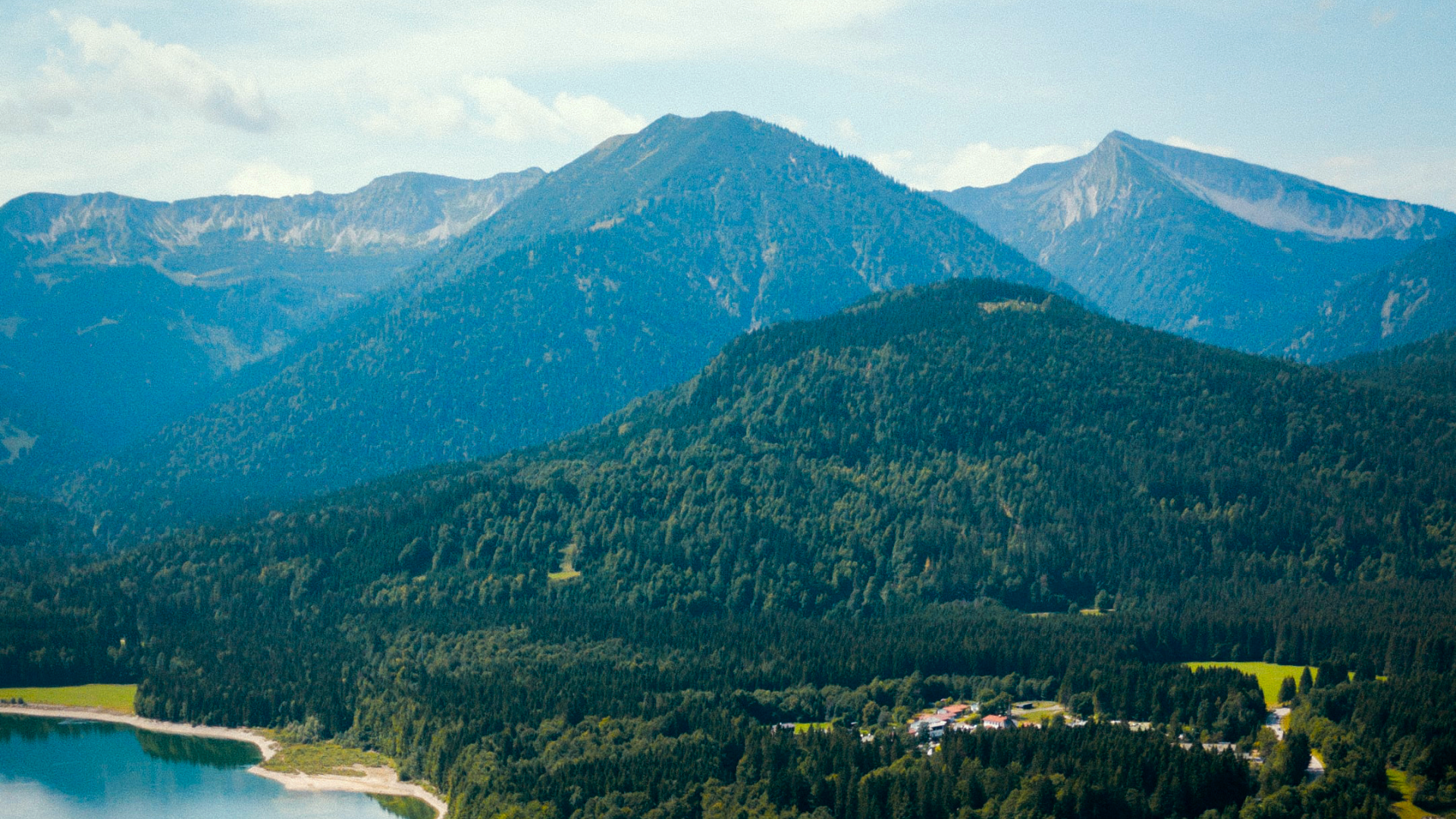 Zdjęcie przedstawia górski krajobraz. Widoczny jest również fragment jeziora.