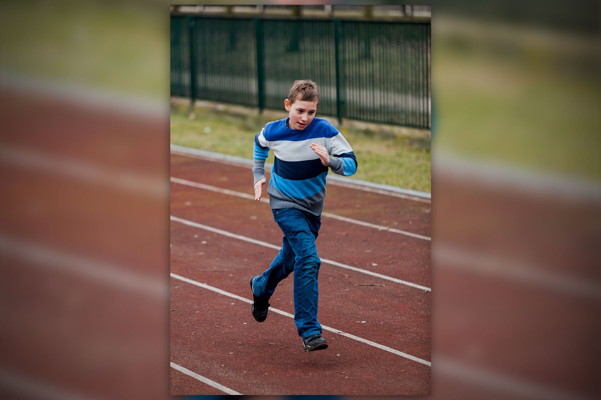 Fotografia przedstawia biegnącego po bieżni chłopca. Ma na sobie czarno-niebieski sweter w pasy i niebieskie dżinsy. Lewa i prawa strona zdjęcia rozmyta.