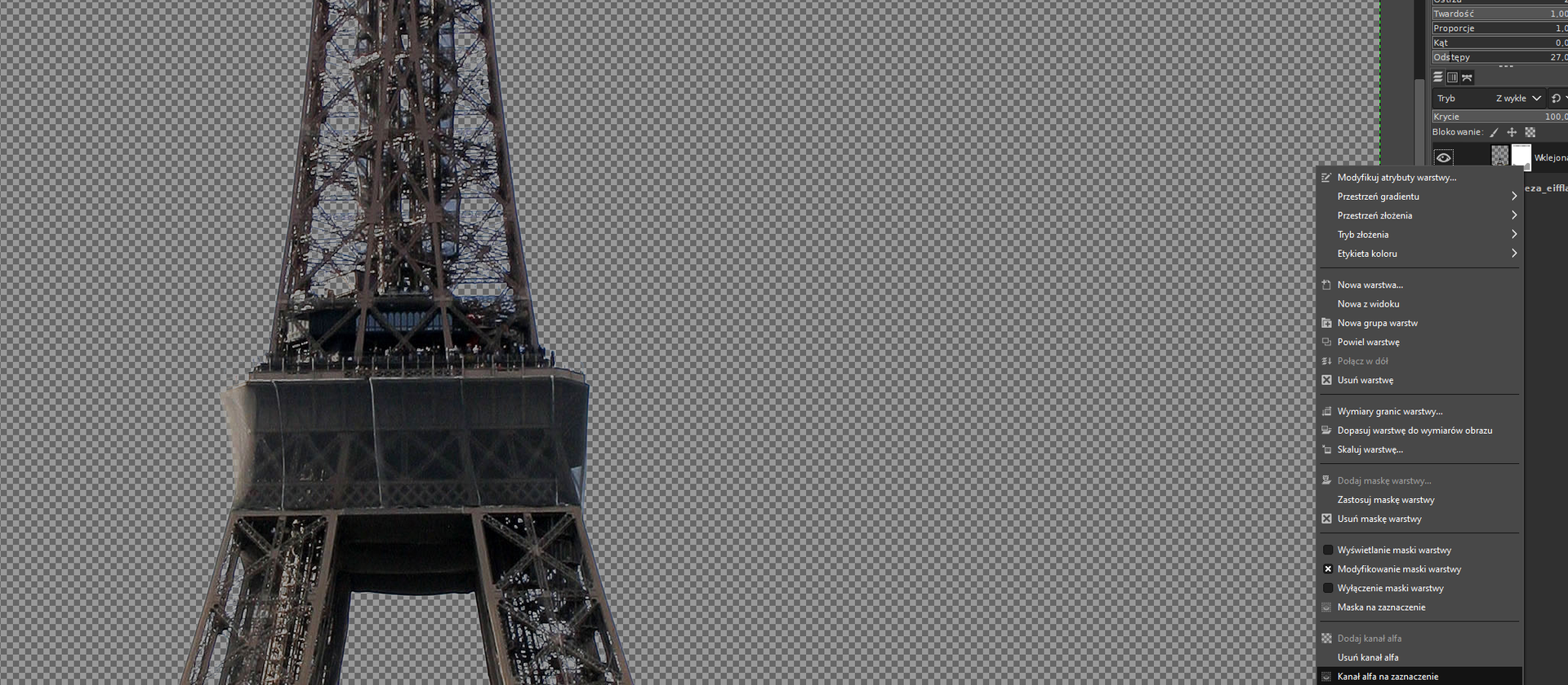 Ilustracja przedstawia okno w programie GIMP. Okno ma kolor szary, na górze i z lewej strony znajduje się podziałka z liczbami. Wewnątrz okna znajduje się fragment wieży Eiffla - górny taras i część iglicy. Tło obrazka – niebo jest pokryte drobną, biało – szarą kratką. Inne elementy ze zdjęcia są wymazane, widać na nim tylko wieżę Eiffla bez podstawy. Po prawej stronie obrazka widoczny jest pasek pod tytułem:  Pencil Generic , a na nim rozwinięta jest lista menu z opcjami wyboru: Modyfikuj atrybuty warstwy, Przestrzeń gradientu, Przestrzeń złożenia, Tryb złożenia, Etykieta koloru, Nowa warstwa…, Nowa z widoku, Nowa grupa warstw, Powiel warstwę, Połącz w dół, Zaznaczona krzyżykiem opcja: Usuń warstwę, Wymiary granic warstwy…, Dopasuj warstwę do wymiarów obrazu, Skaluj warstwę…, Dodaj maskę warstwy…, Zastosuj maskę warstwy, Zaznaczona krzyżykiem opcja: Usuń maskę warstwy, Wyświetlanie maski warstwy, Zaznaczona krzyżykiem opcja: Modyfikowanie maski warstwy, Wyłączenie maski warstwy, Maska na zaznaczenie, Dodaj kanał alfa, Usuń kanał alfa oraz wybrana pozycja listy: Kanał alfa na zaznaczenie. 
