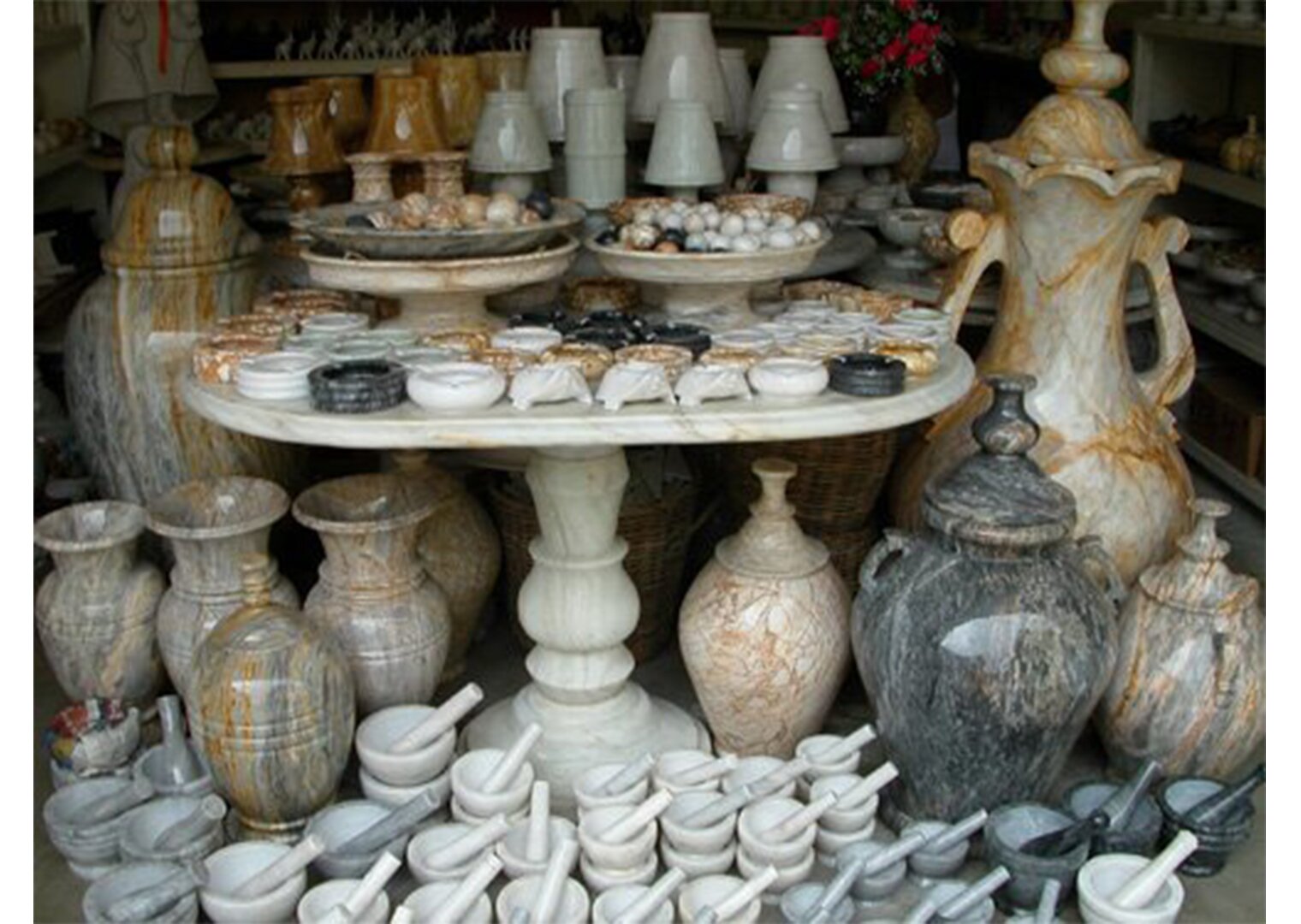 NA zdjęciu figurki wykonane z marmuru: wazy, moździerze, popielniczki, miseczki, małe lampy.