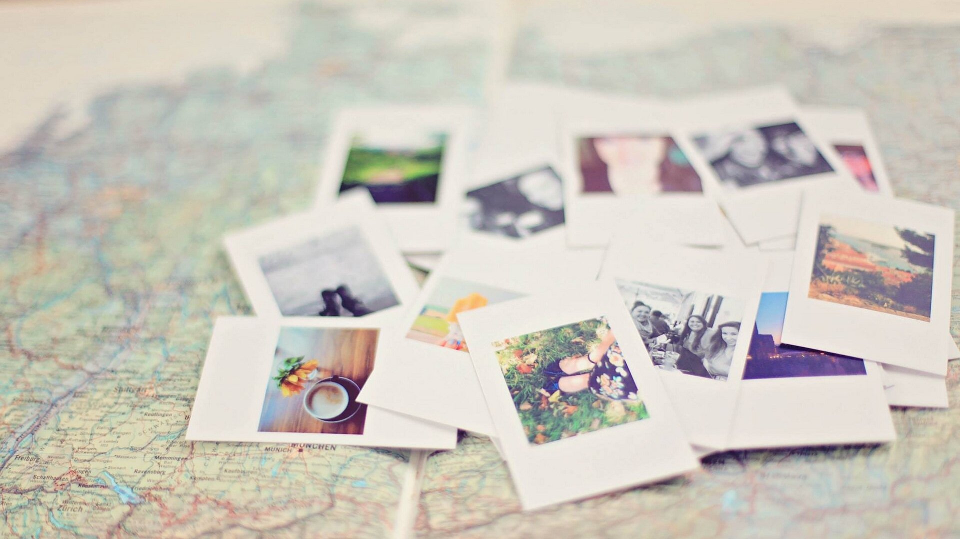 Zdjęcie przedstawia mapę z ułożonymi na niej fotografiami, na których widać m.in. kawę w filiżance ustawionej na stole, stojącą osobę w czarnych butach na trawie, grupę ludzi w restauracji, góry. 