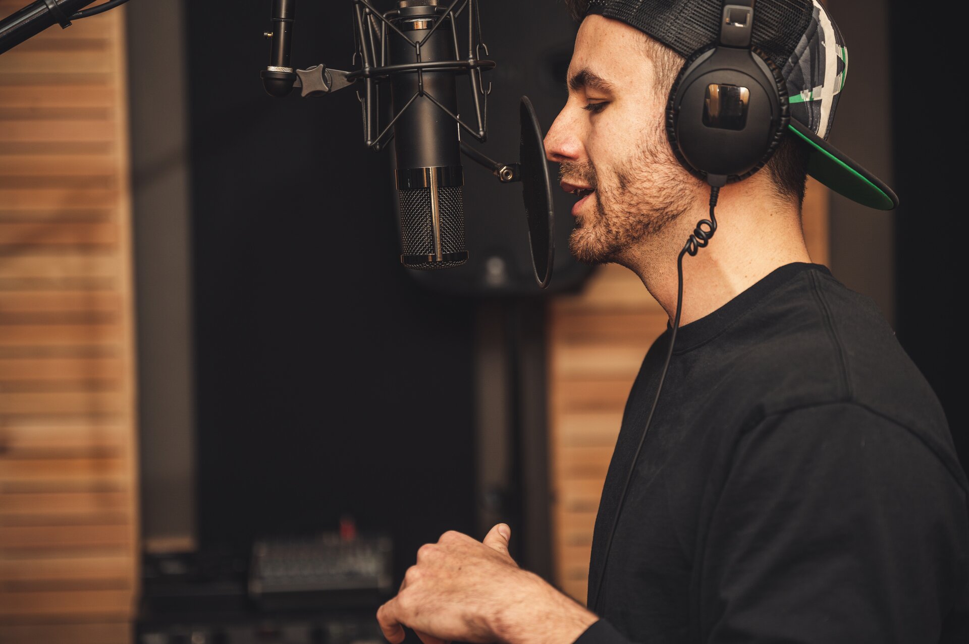 Ilustracja przedstawia mężczyznę. Jest on z zawodu muzykiem - piosenkarzem. Na zdjęciu mężczyzna przebywa w studio nagrań i być może nagrywa nową piosenkę. Ma na uszach słuchawki i śpiewa do specjalnego mikrofonu. Zadanie alternatywne wyświetla się w trybie dostępności.