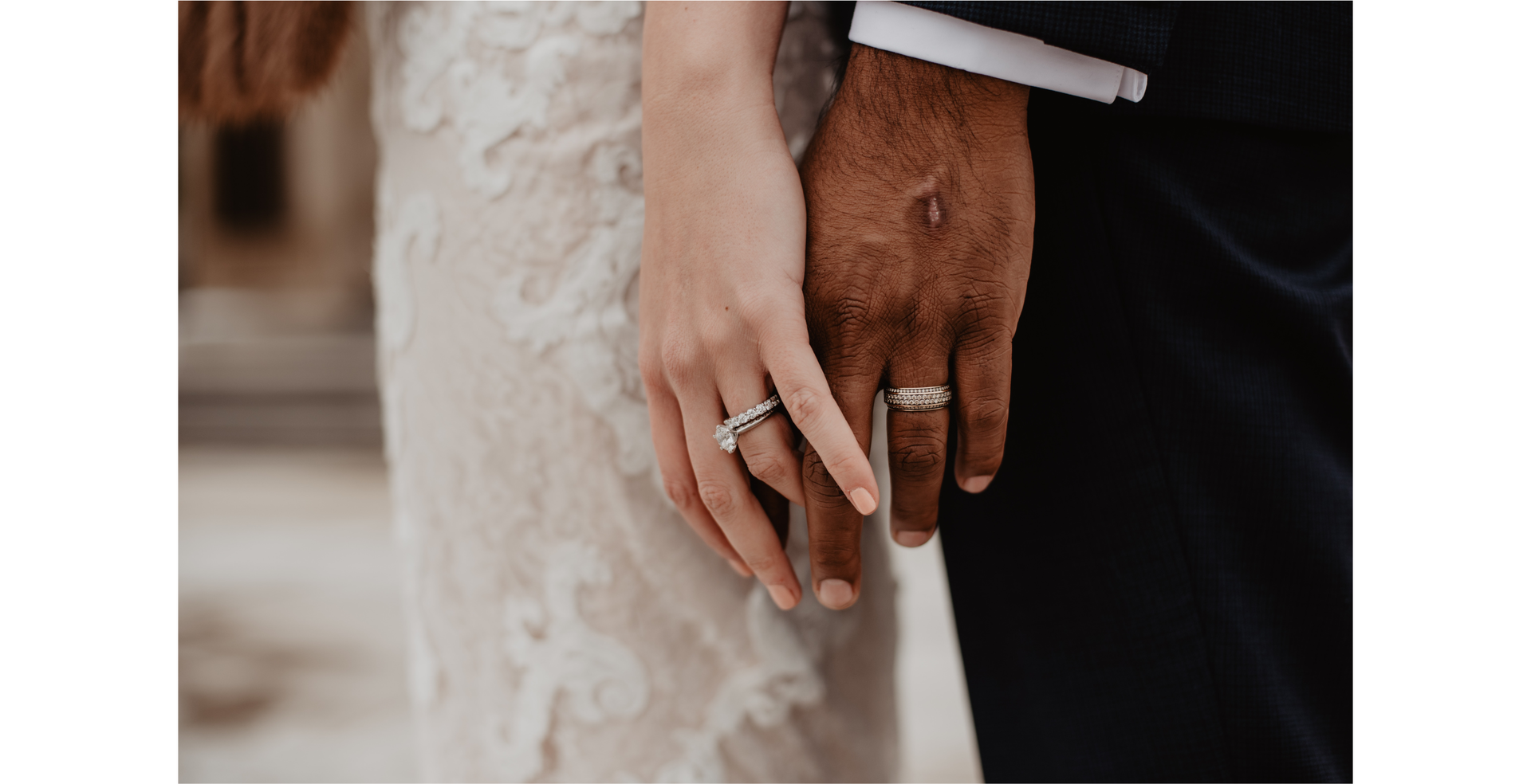 Na zdjęciu widoczne są dłonie stojącej obok siebie pary młodej. Oboje mają obrączki na palcach. 