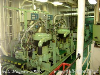 Zdjęcie przedstawia dwie wirówki paliwa. Są to stożkowate zbiorniki z licznymi rurkami i kablami.