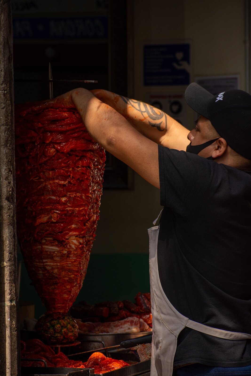 Nabijanie mięsa na opiekacz. Na drugim zdjęciu widoczny jest mężczyzna, który stoi przy opiekaczu, w którym przygotowane jest mięso na kebab.